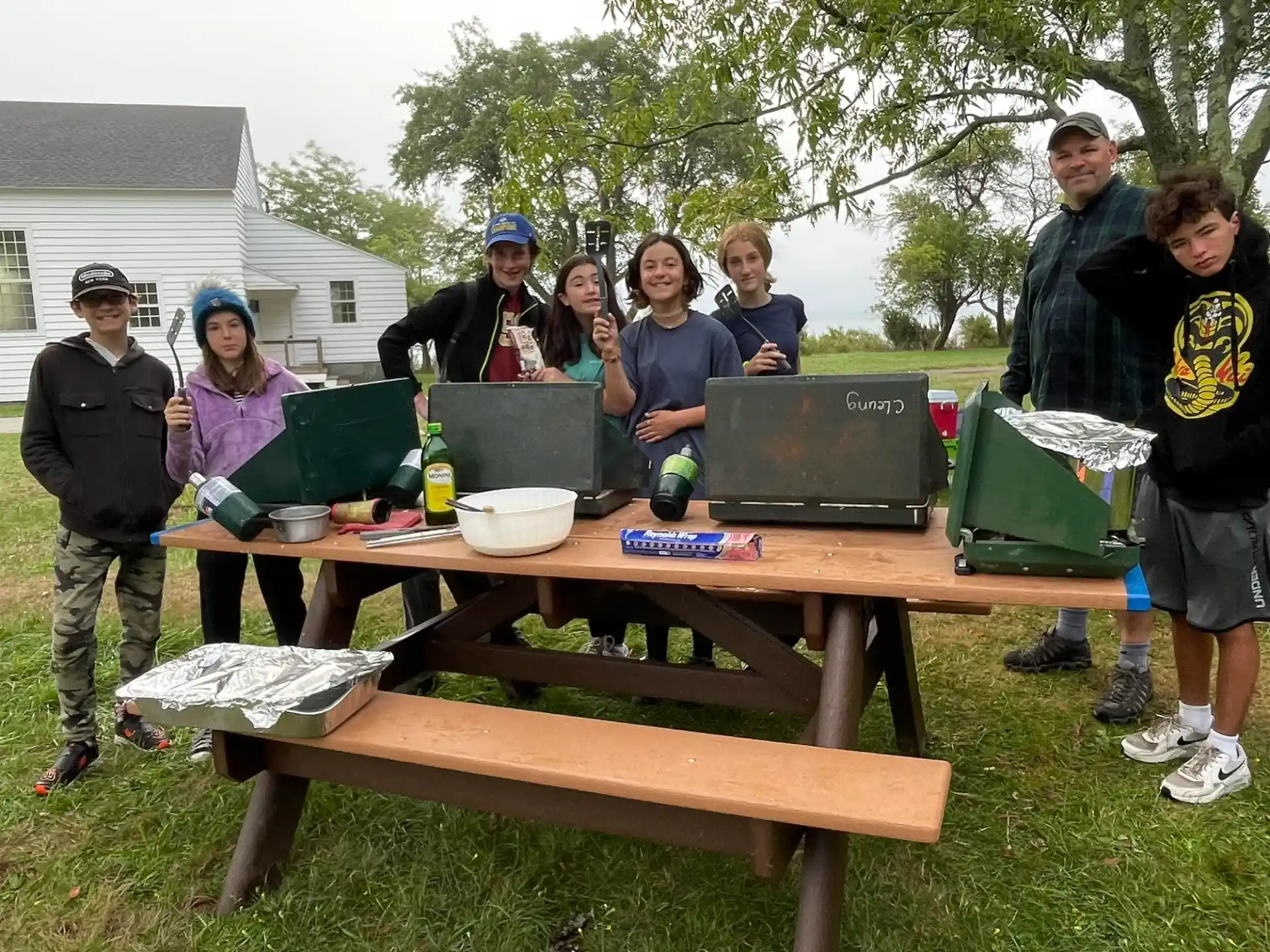 a group of people standing around a table outside
