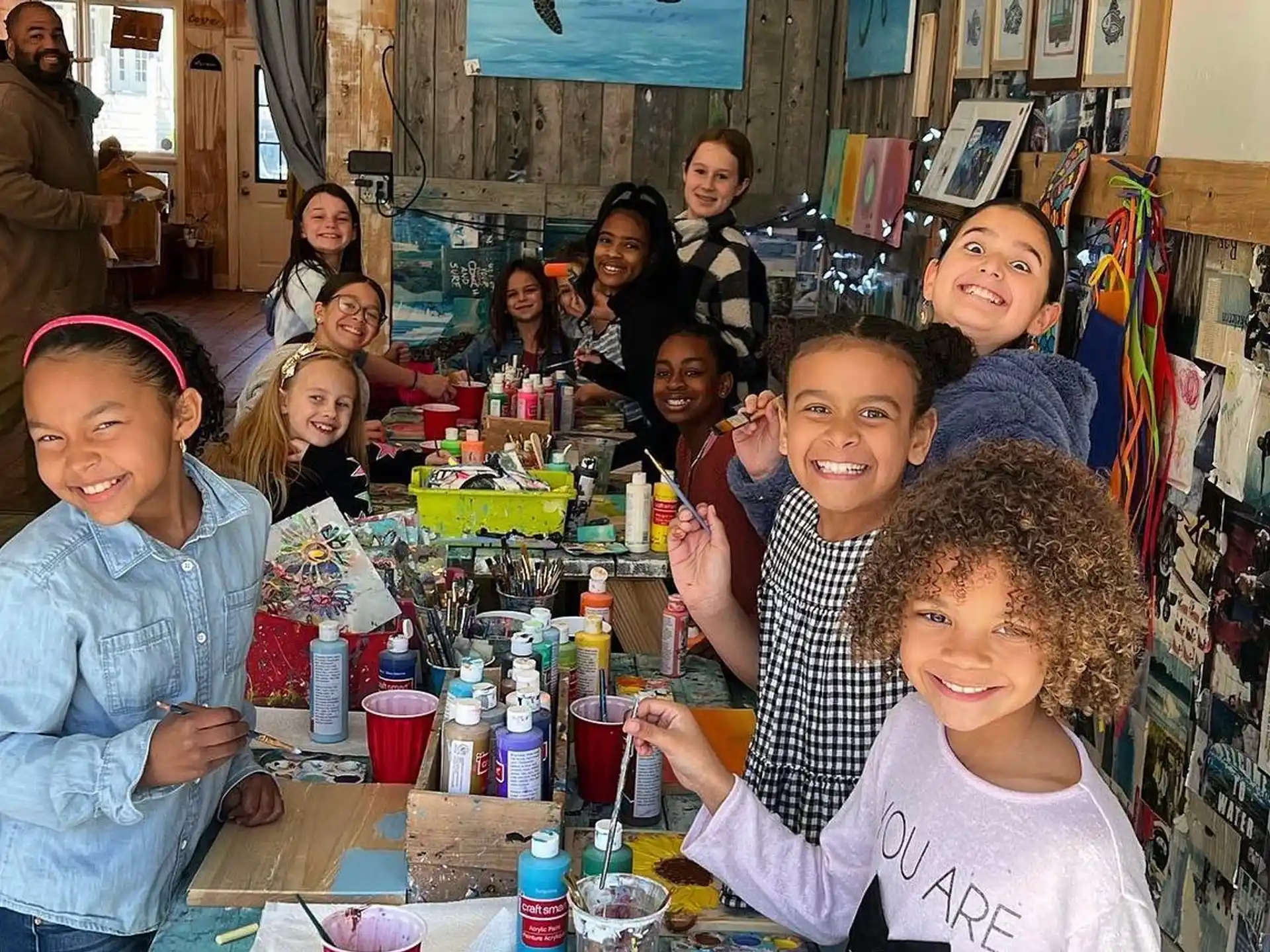 a group of children sitting at a table with drinks