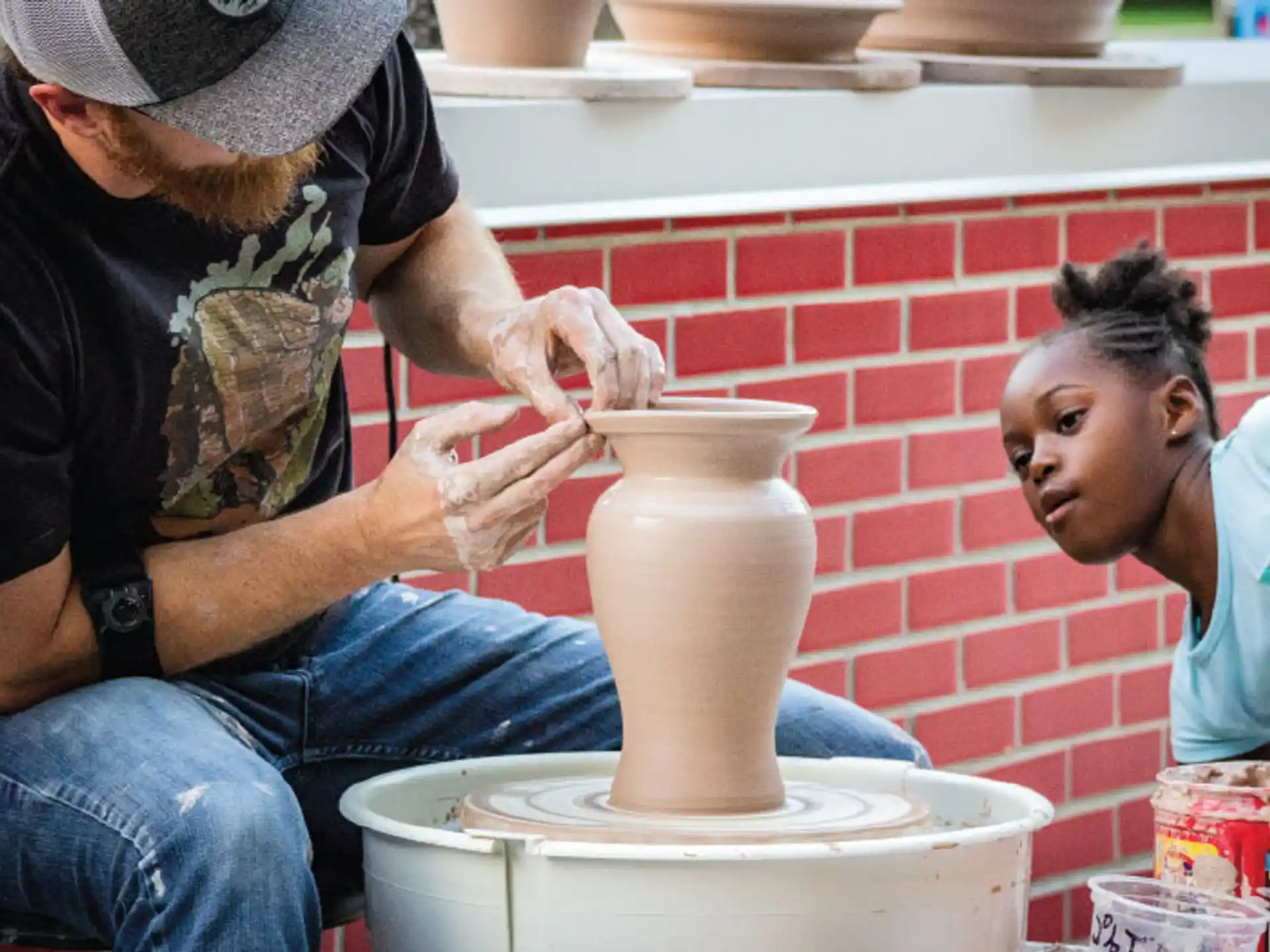 a person pouring a liquid into a vase