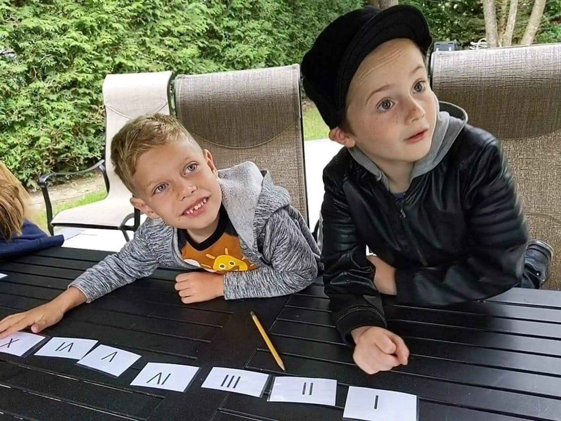a couple of boys sitting at a table with a game board