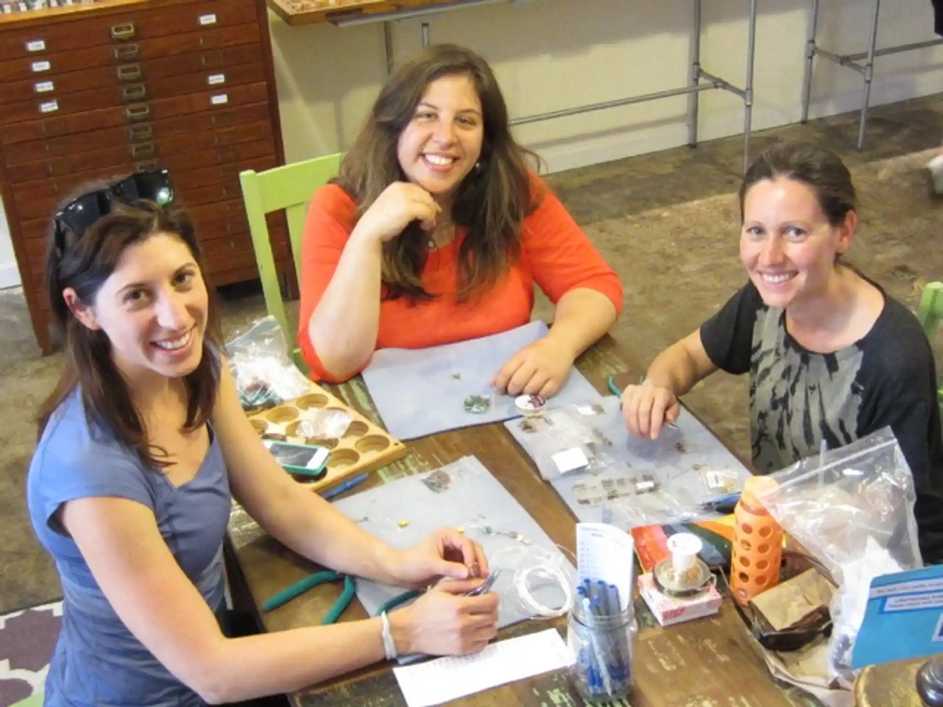 a group of women sitting at a table with food