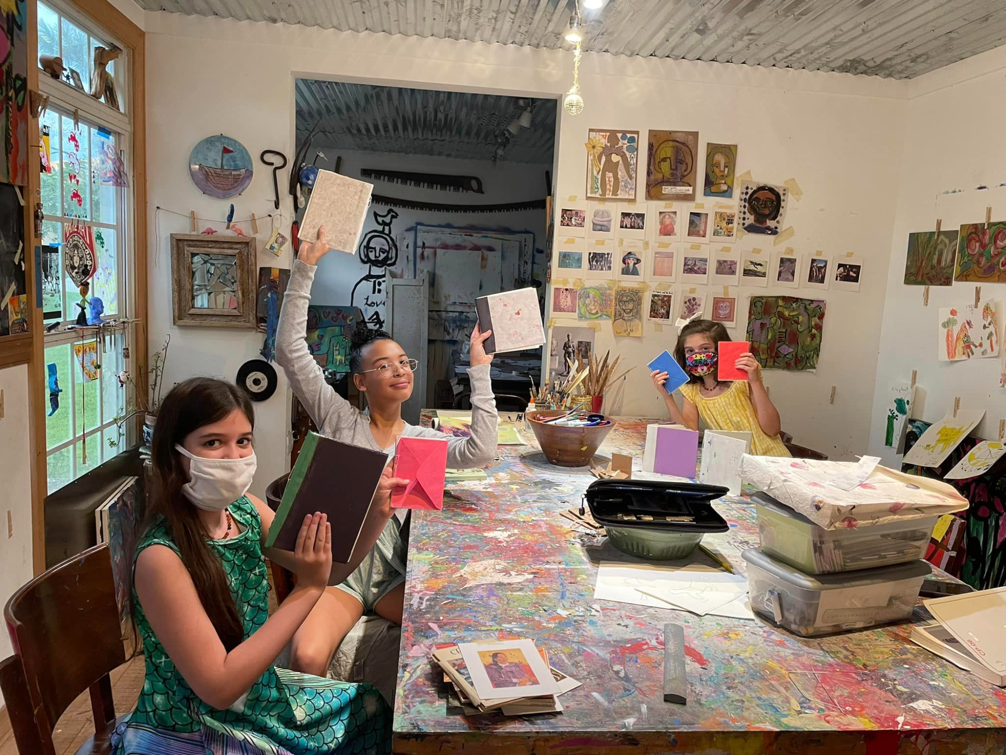 a group of people sitting at a table with books and papers