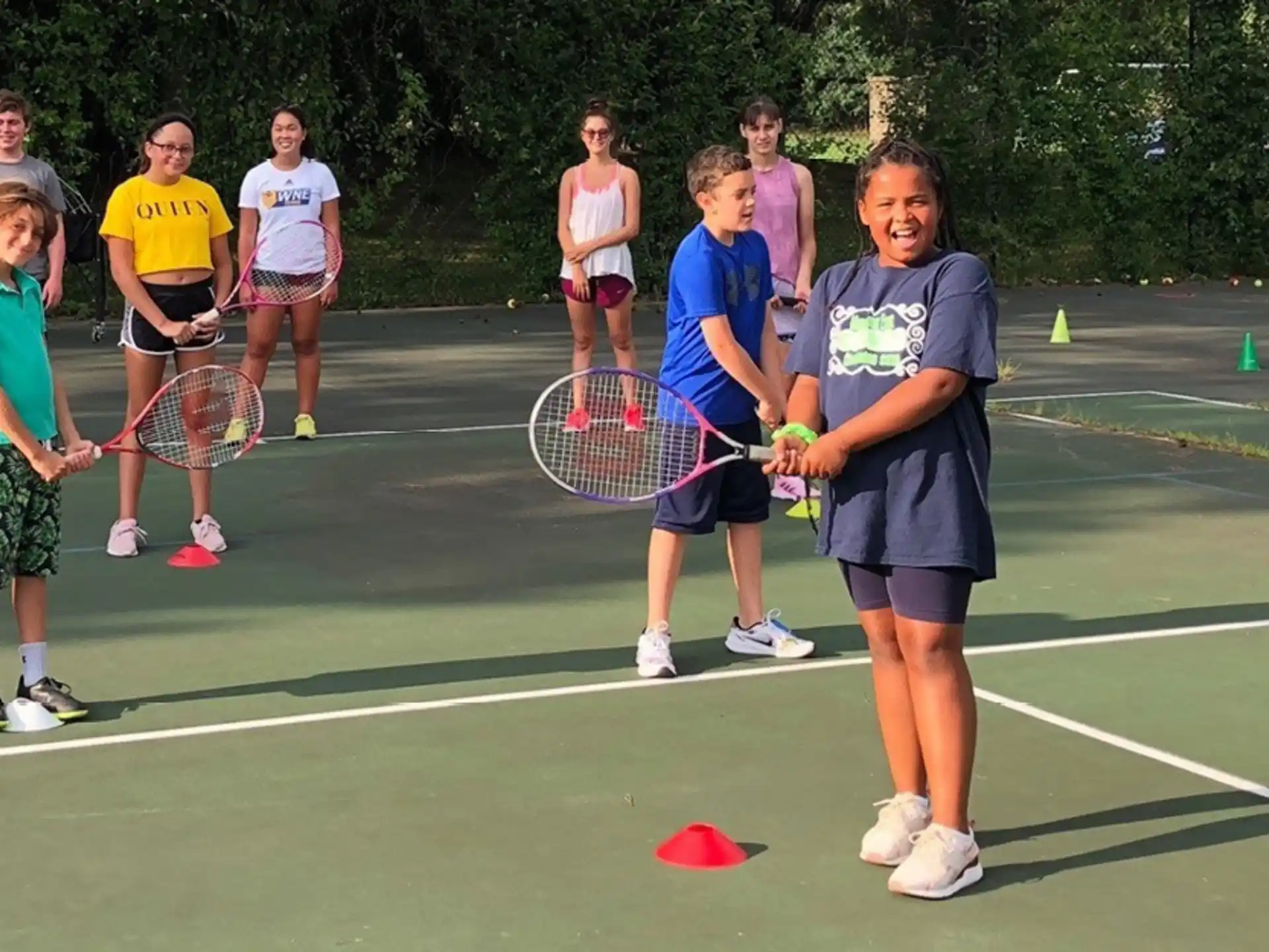 a group of kids holding tennis rackets