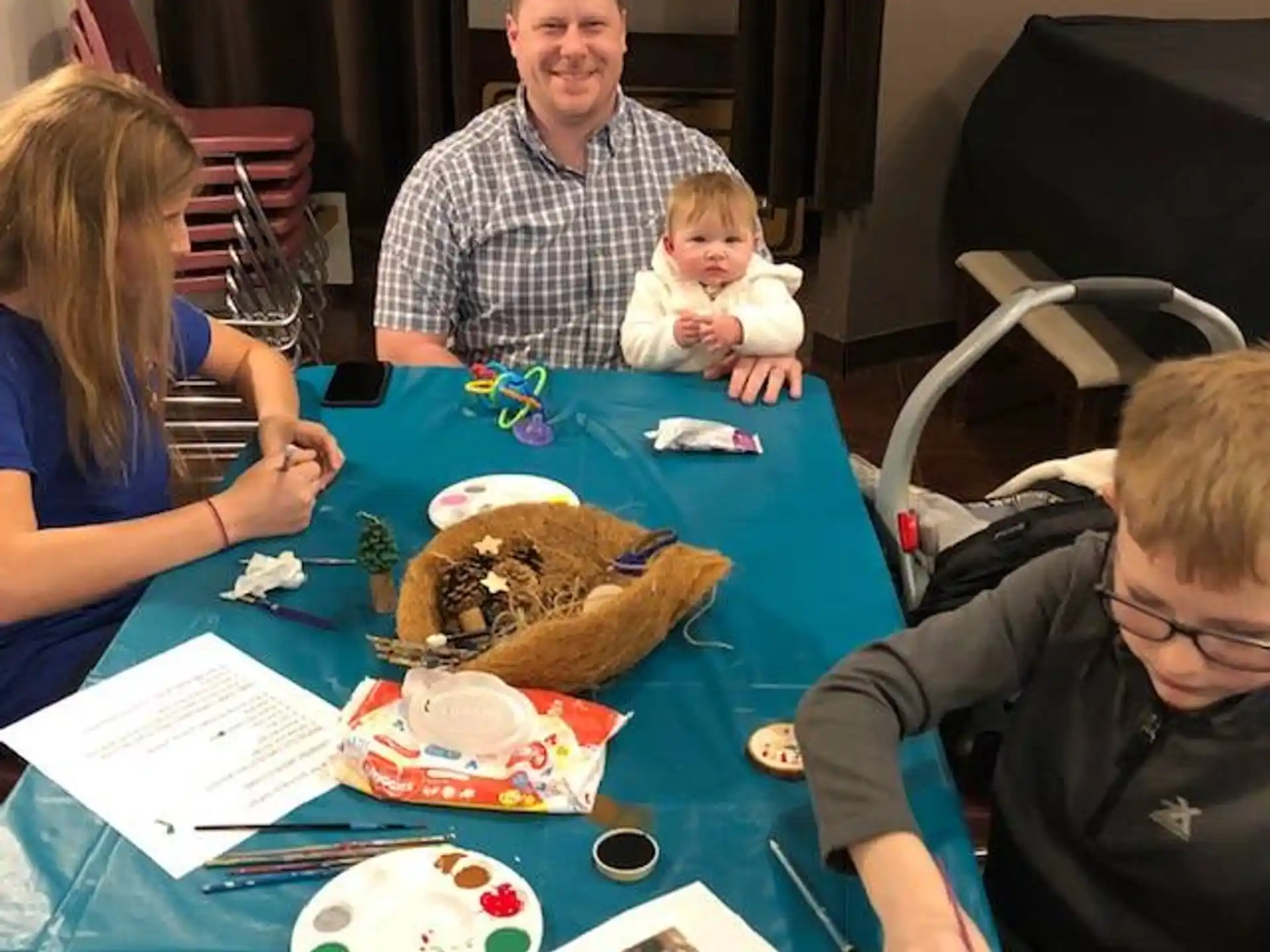 a group of people sitting around a table with a baby
