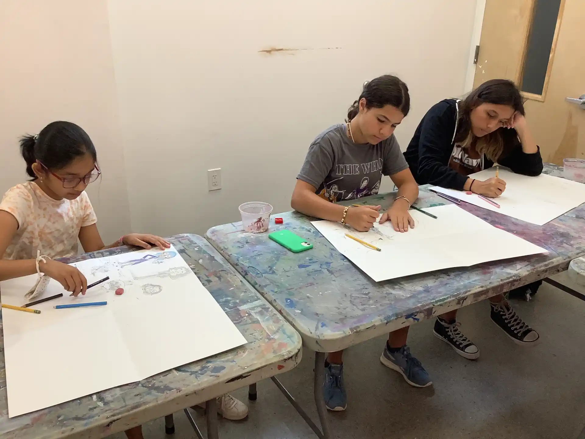 a group of people sitting at a table with a white board