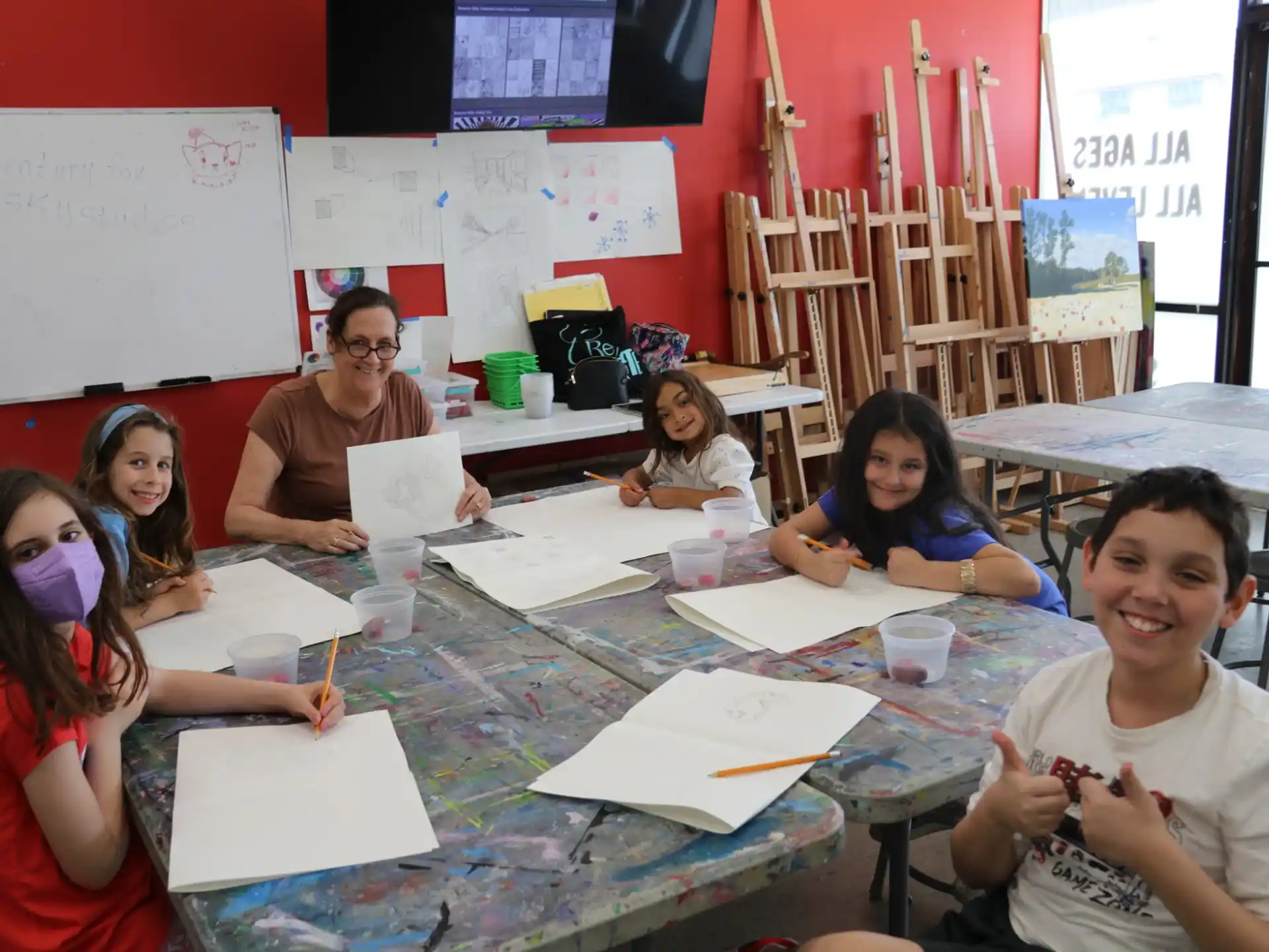 a group of people sitting at a table with papers and pencils
