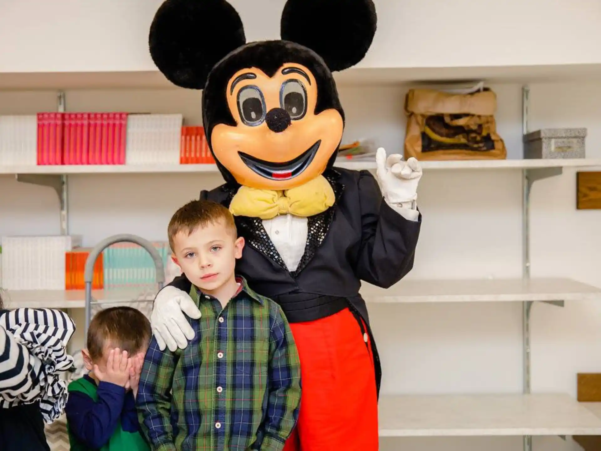 a boy standing next to a person in a garment