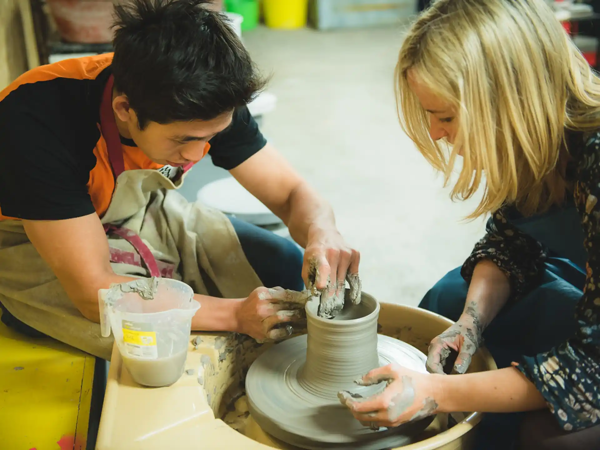 a man and a woman making a teapot