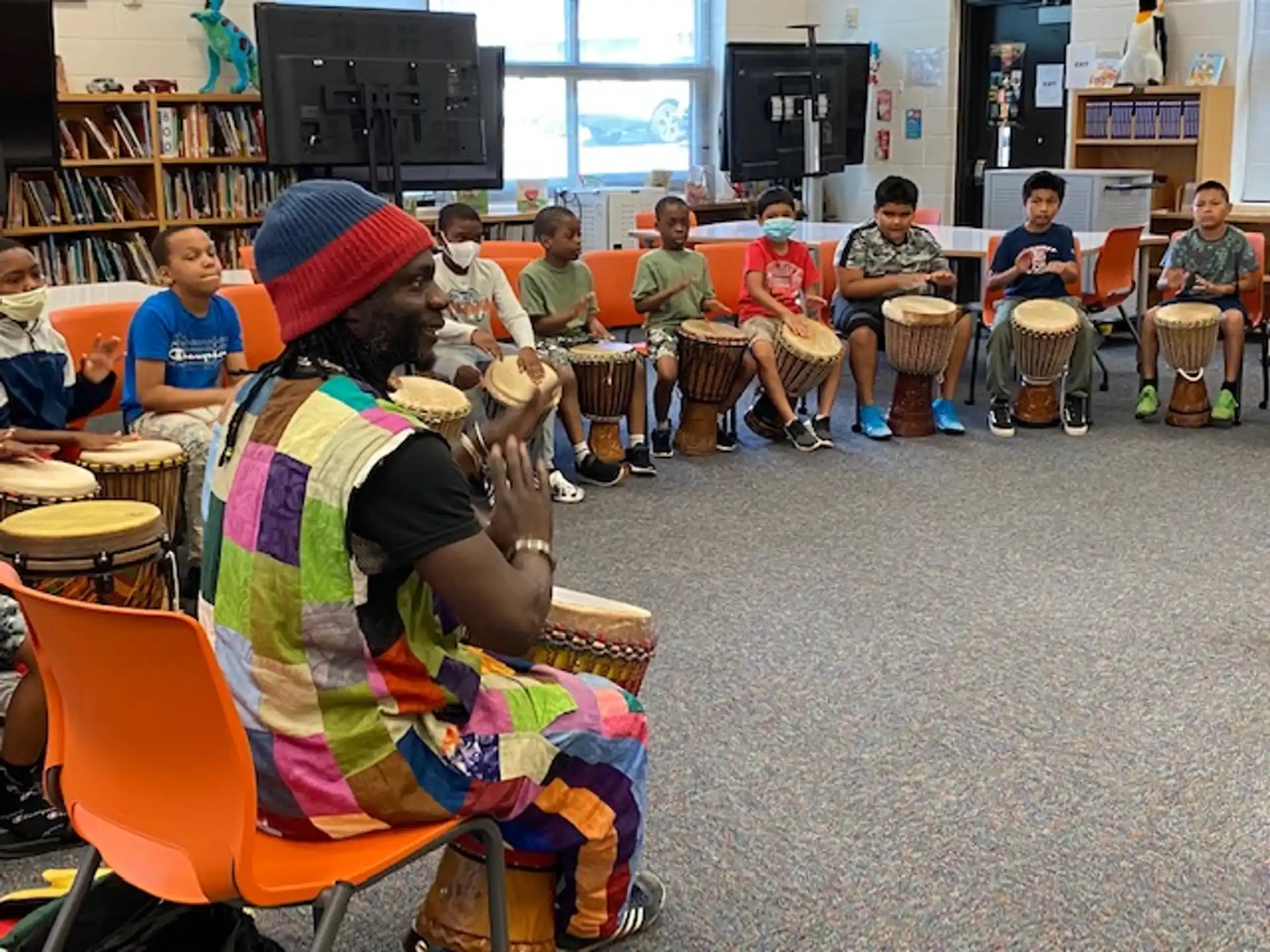 a group of people sitting in a room with drums