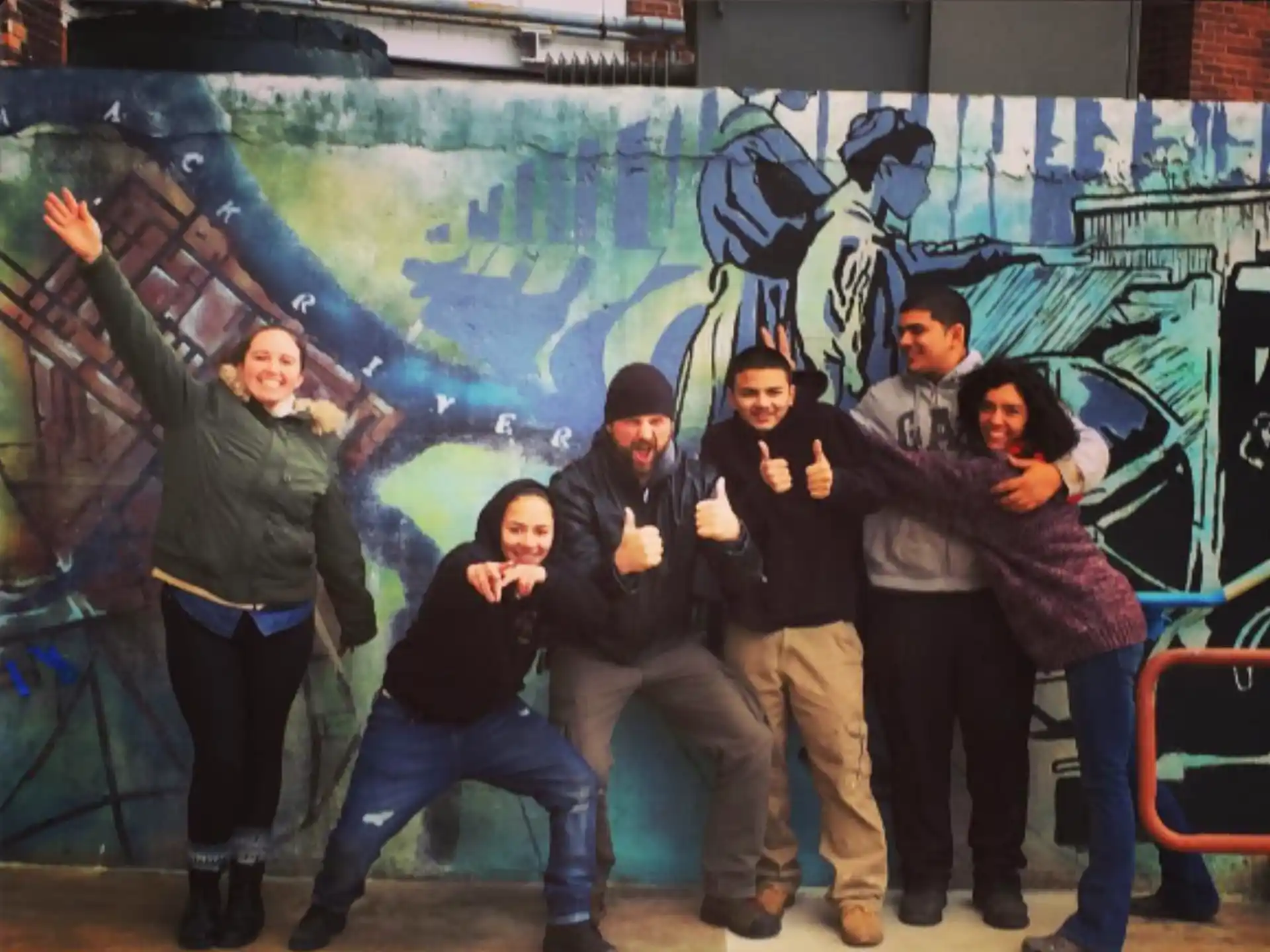 a group of people posing for a photo in front of a wall
