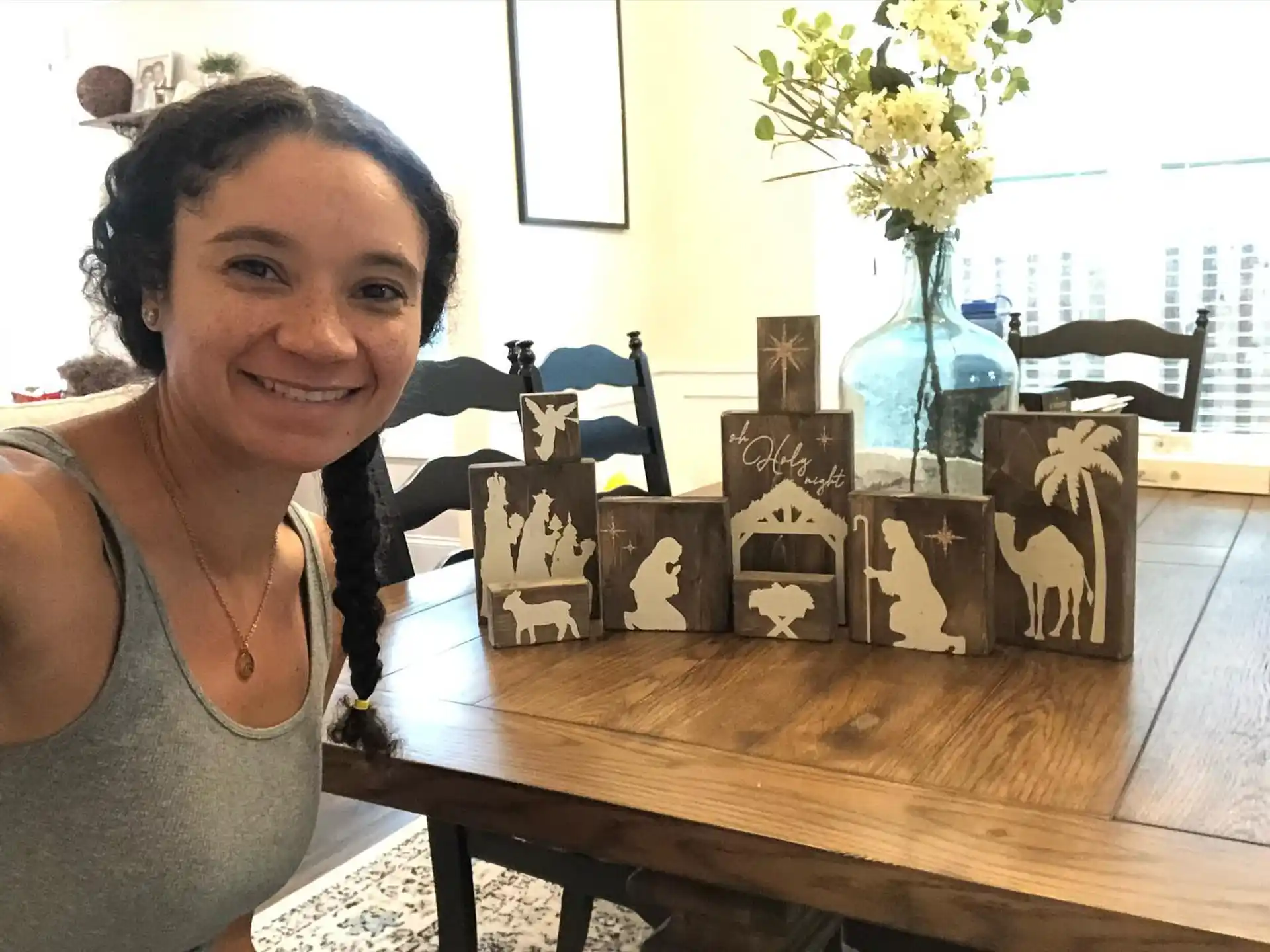 a person sitting at a table with a wood model of a house