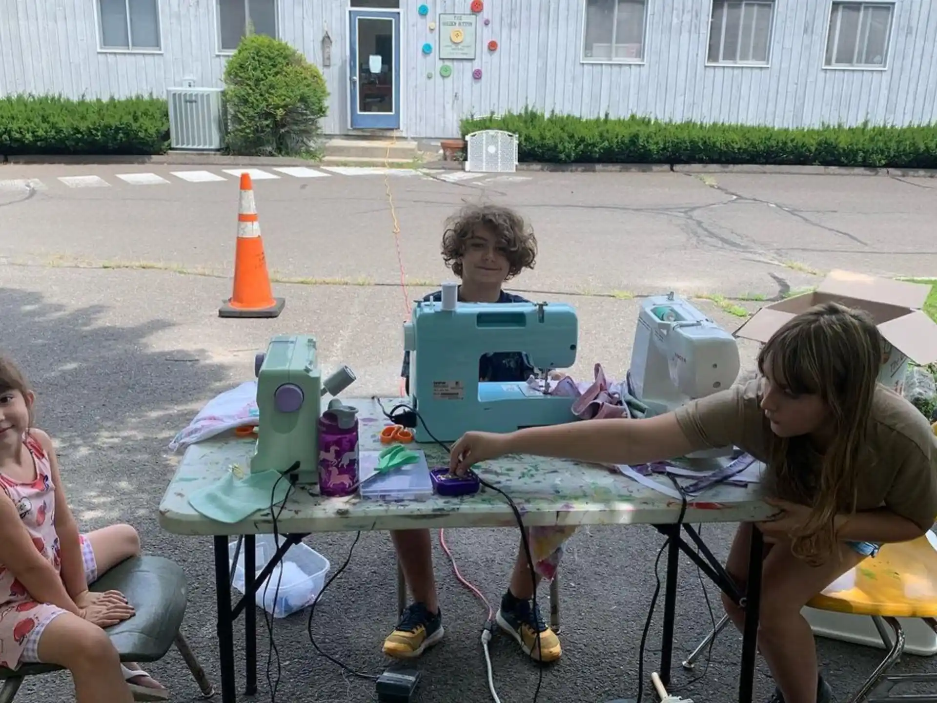 a group of children sitting around a table outside
