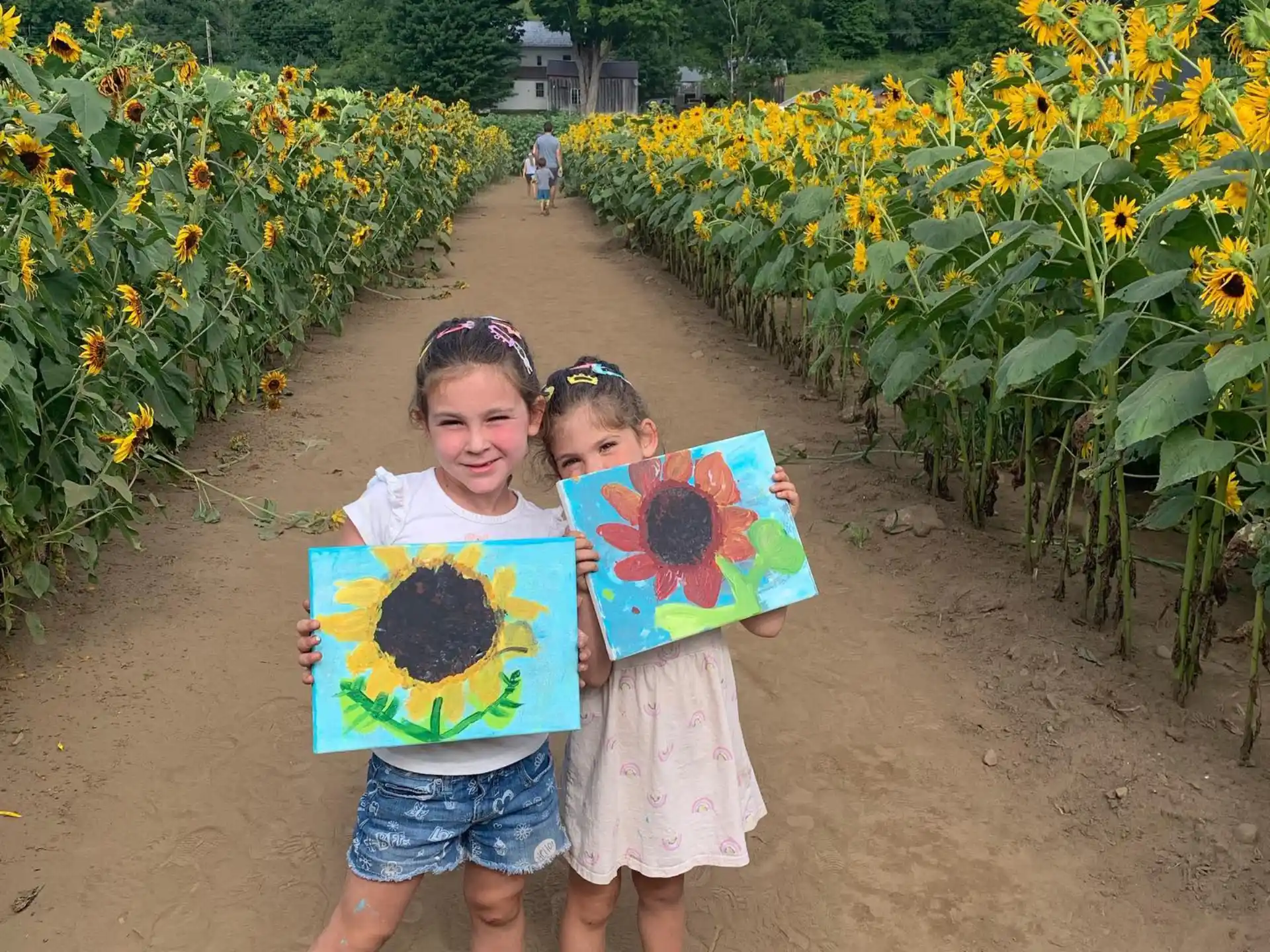 two girls standing in front of a field of flowers