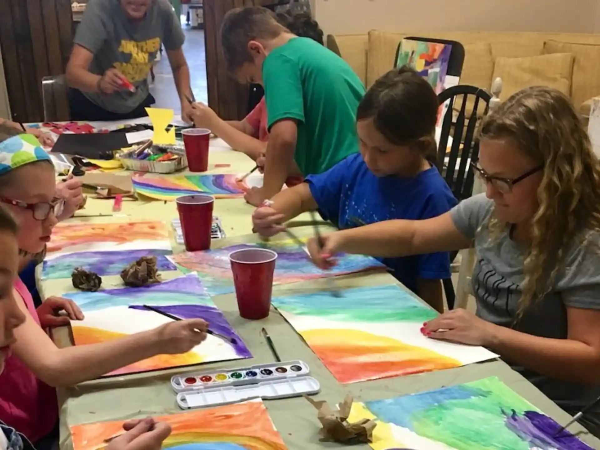 a group of children sitting around a table