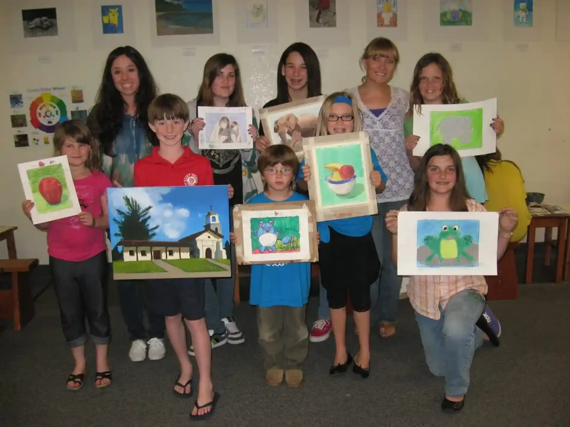 a group of children holding up framed pictures