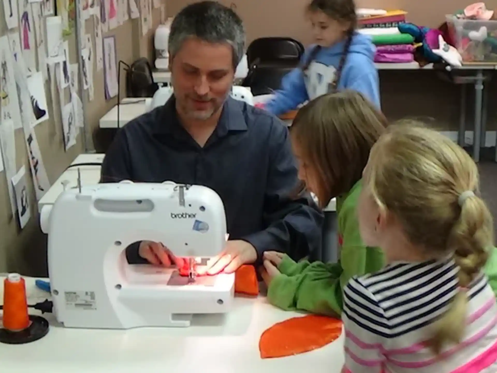 a person and children looking at a sewing machine