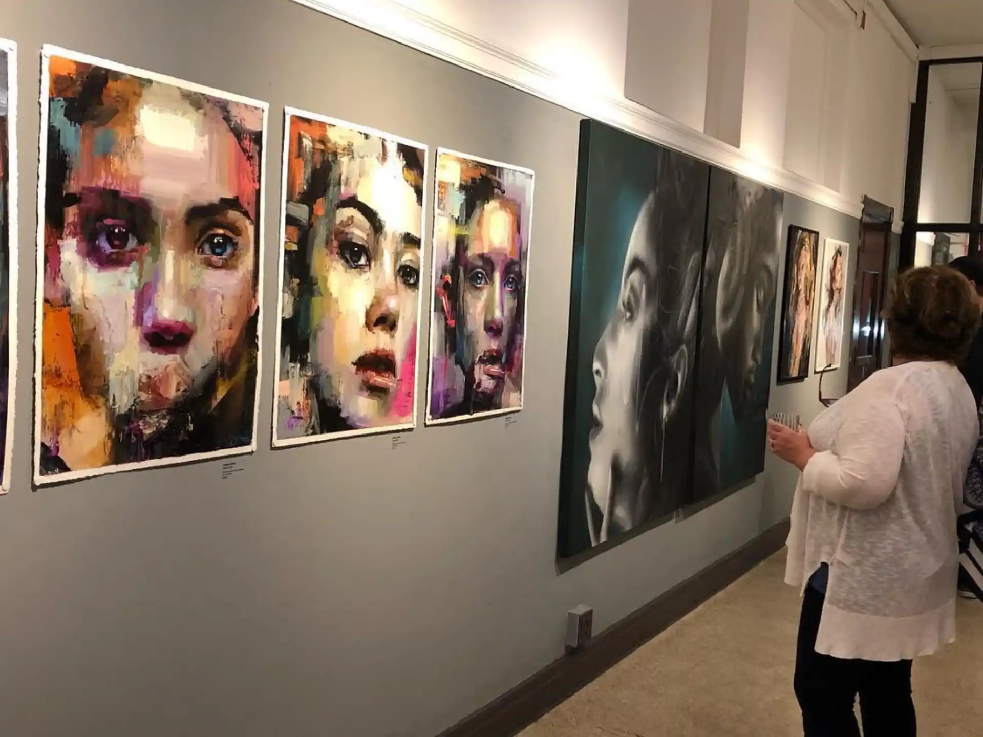 a person looking at a wall of paintings