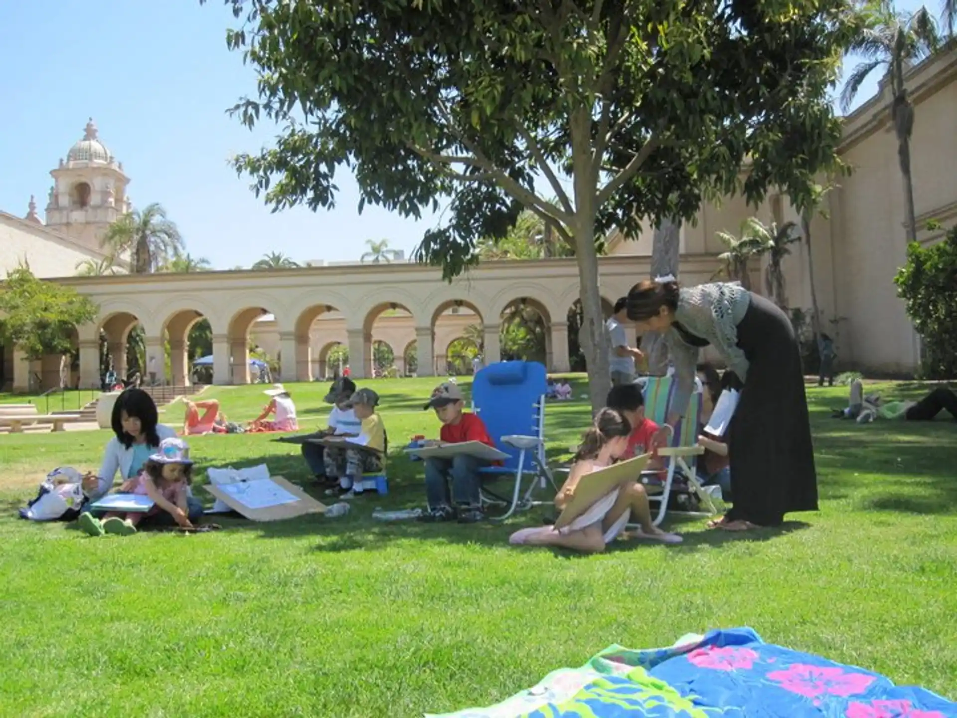 a group of people sitting on the grass in front of a building
