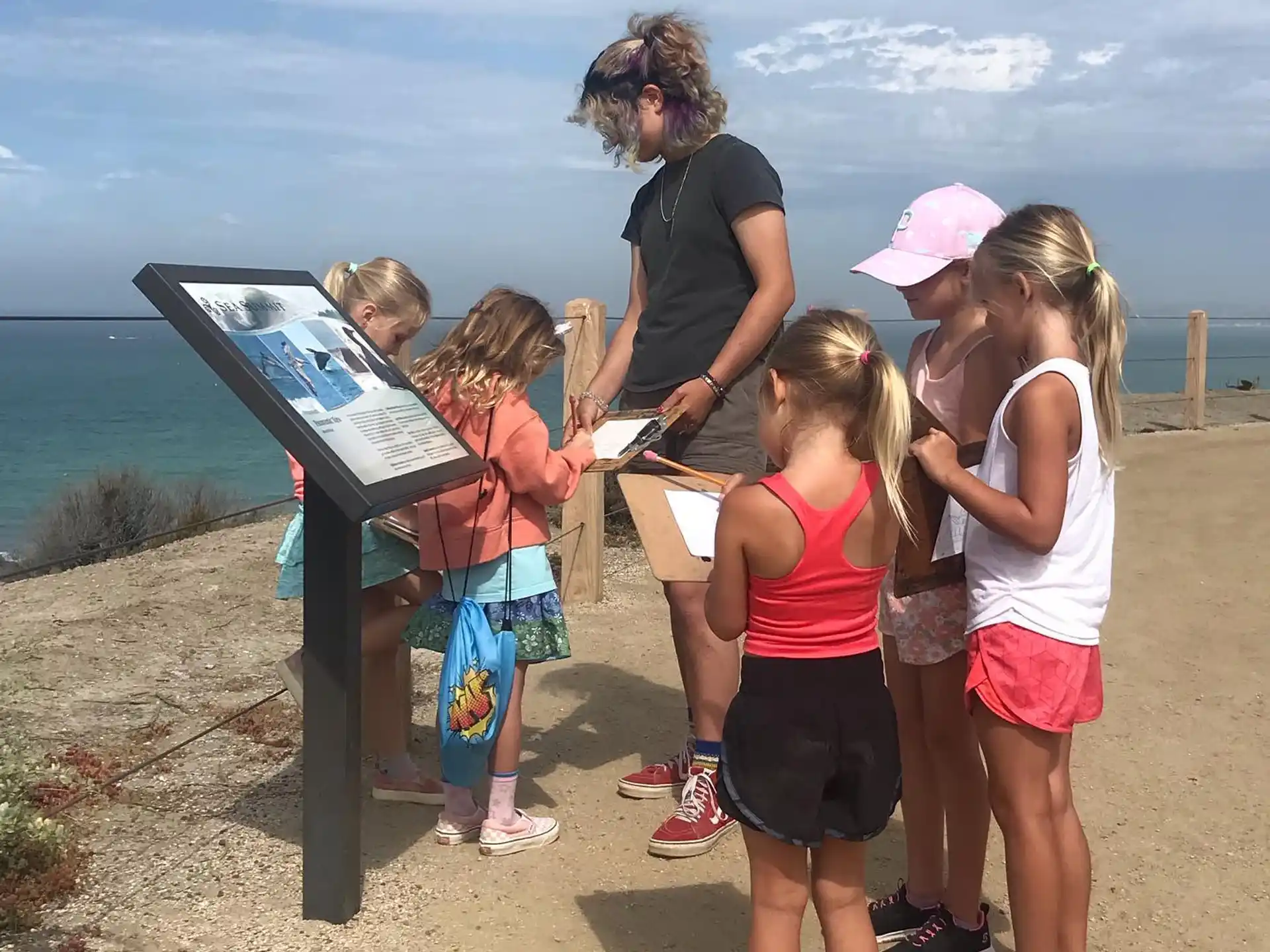 a group of people standing around a table outside