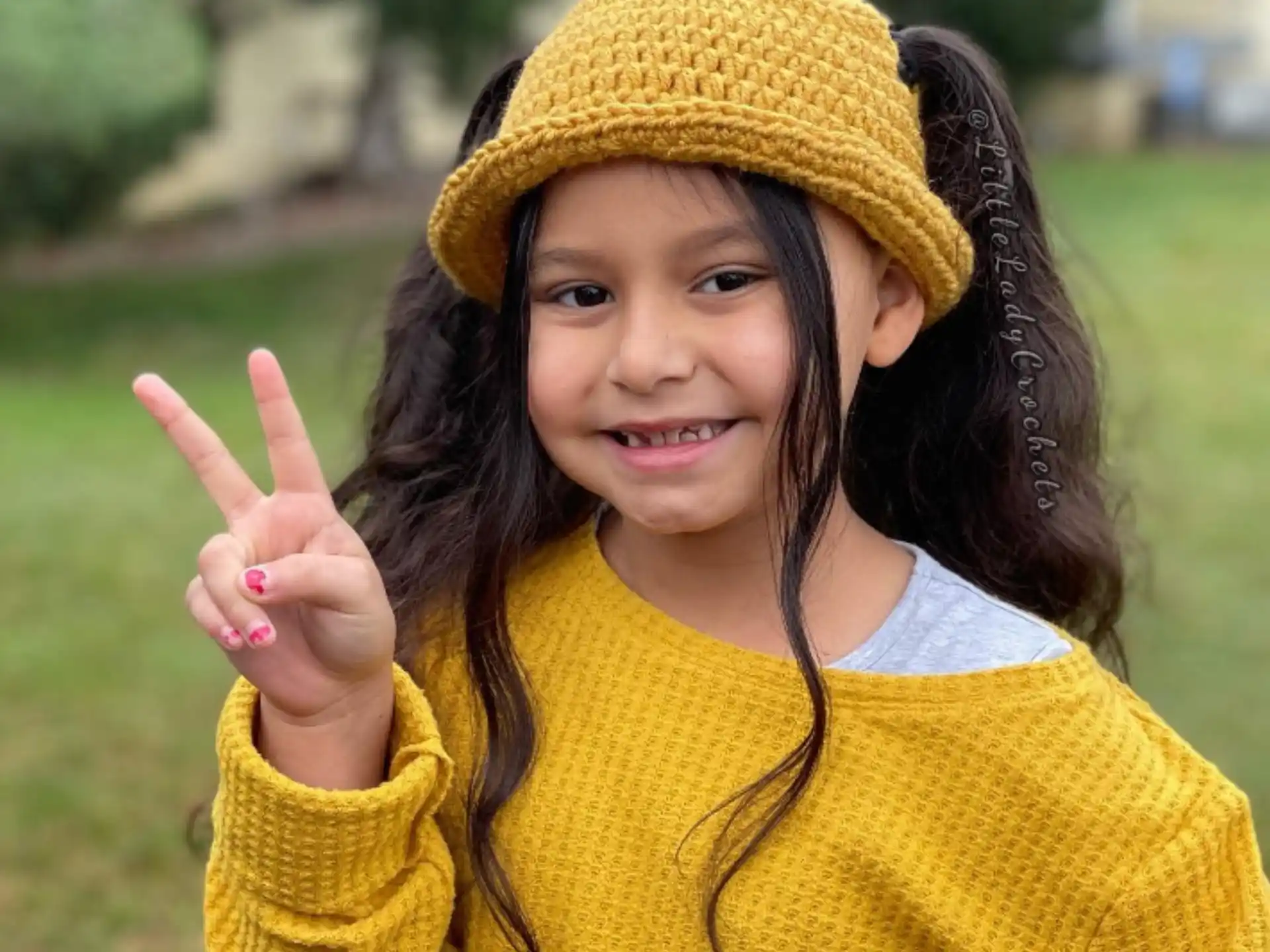 a girl wearing a hat and holding up her middle finger