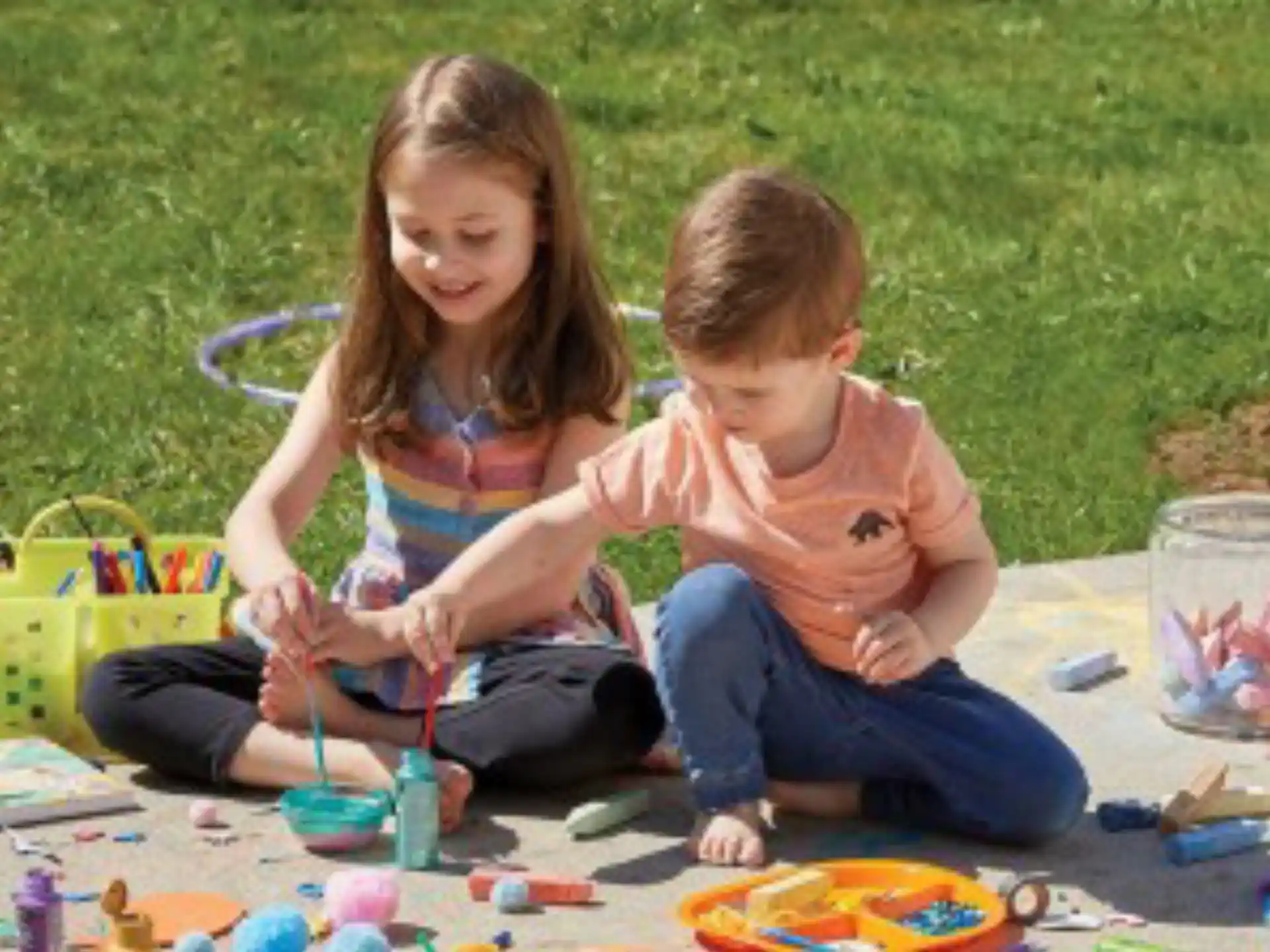 a person and a child playing with toys on the grass