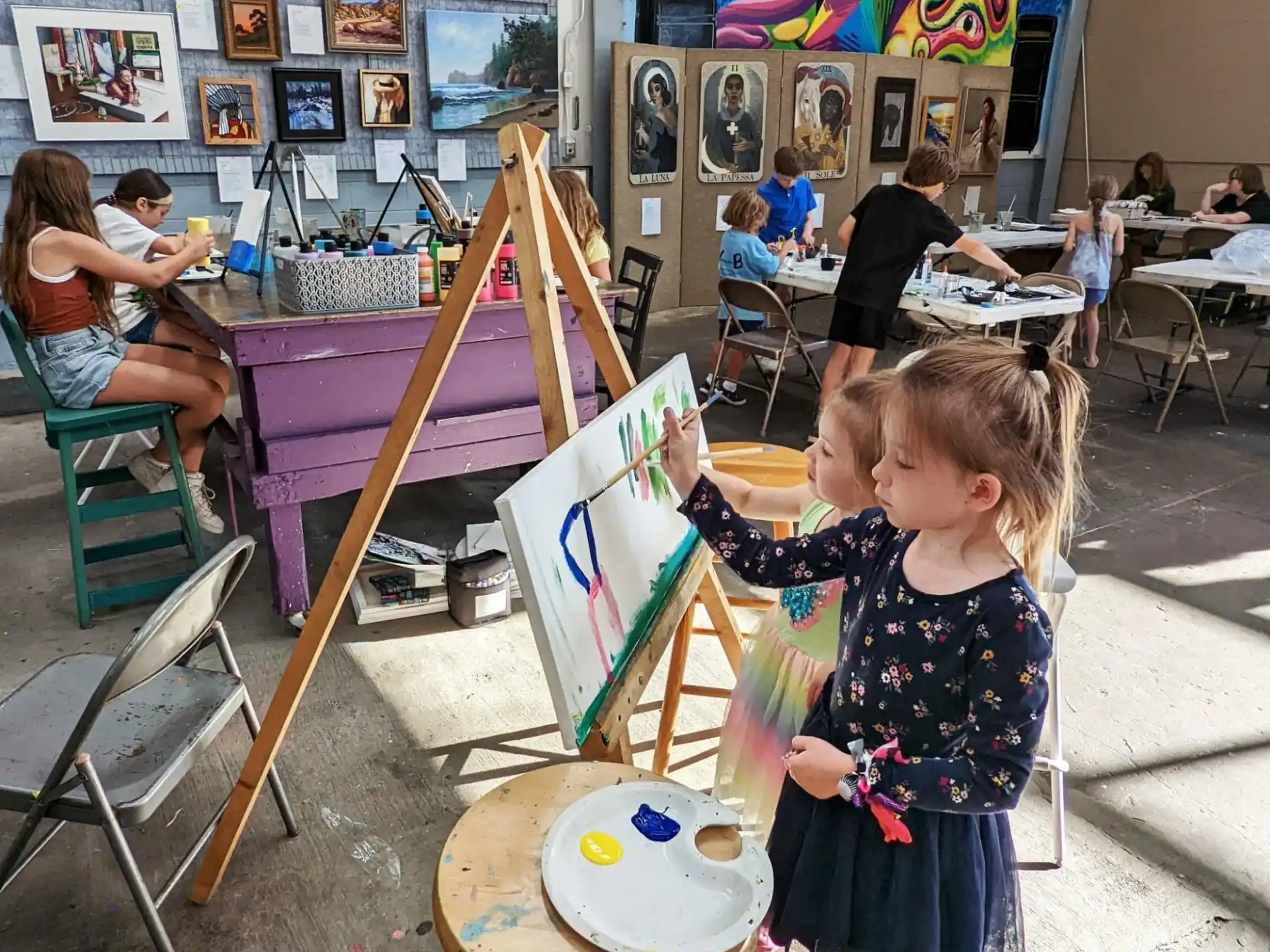 a young girl painting in a classroom