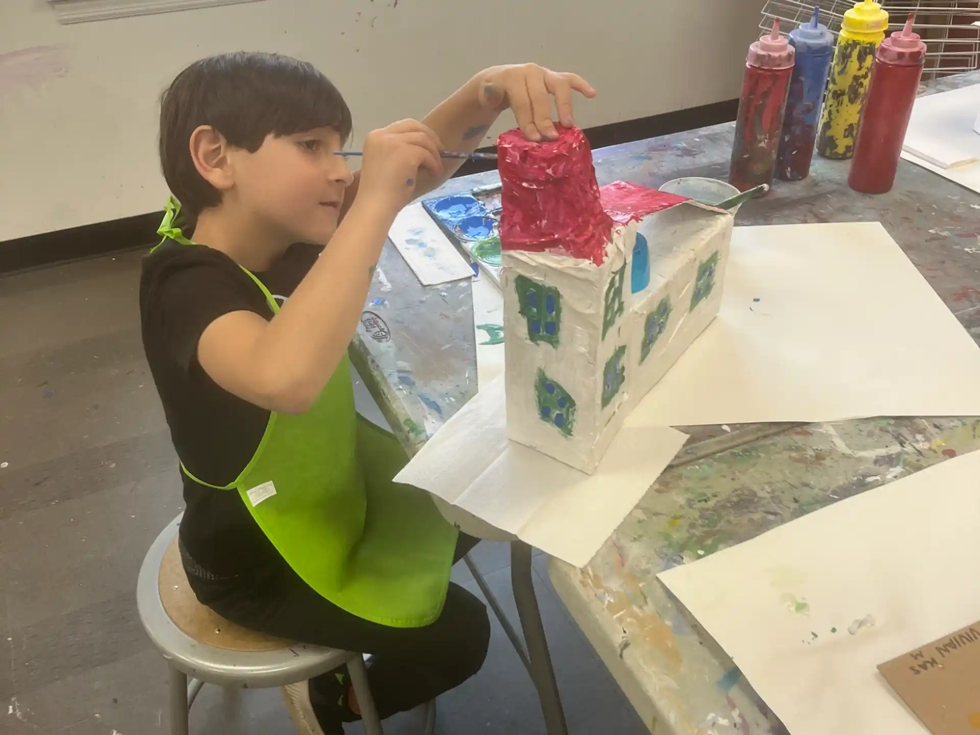 a boy sitting at a table with a box of cookies