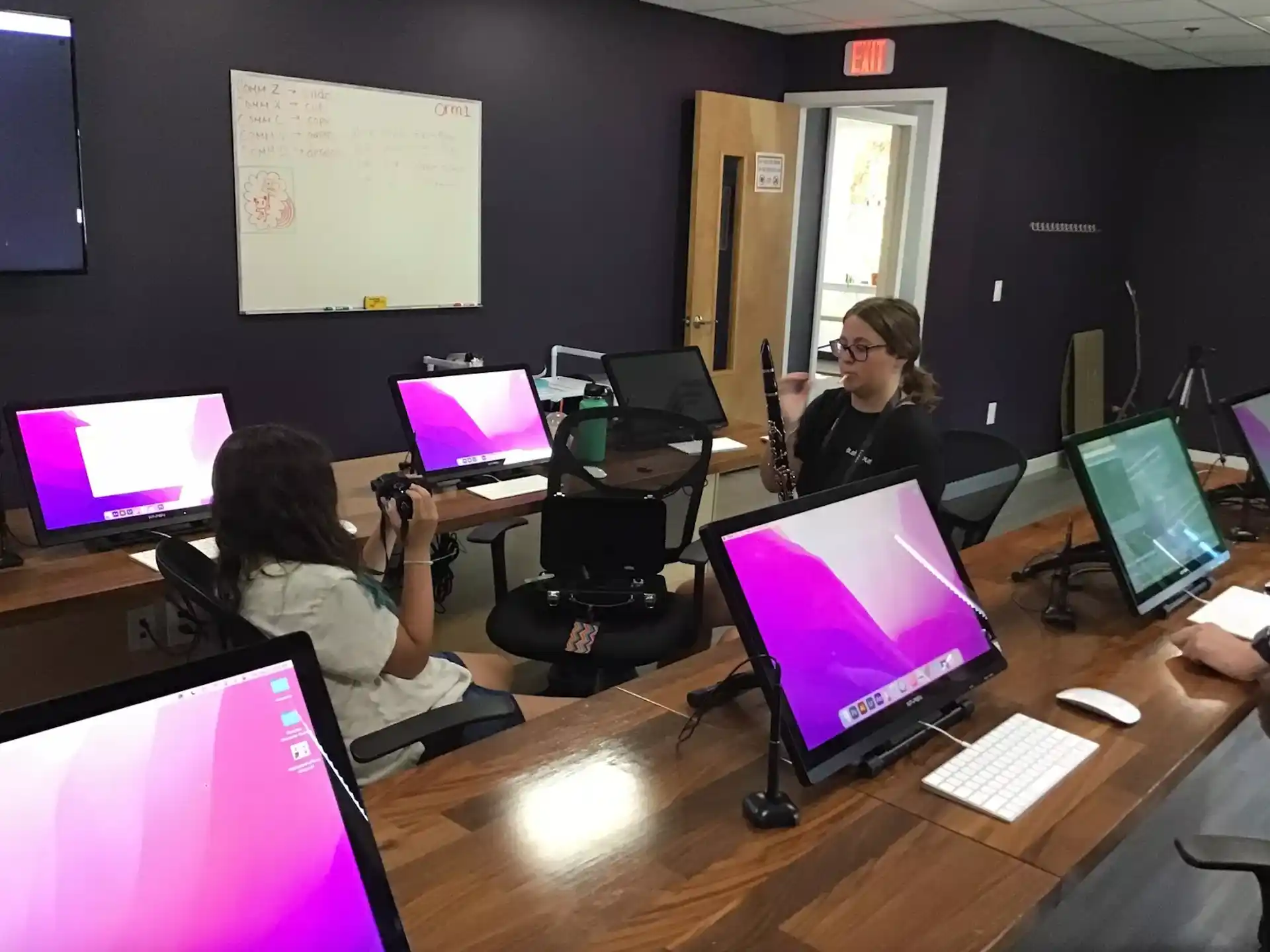 a group of people sitting at a table with computers