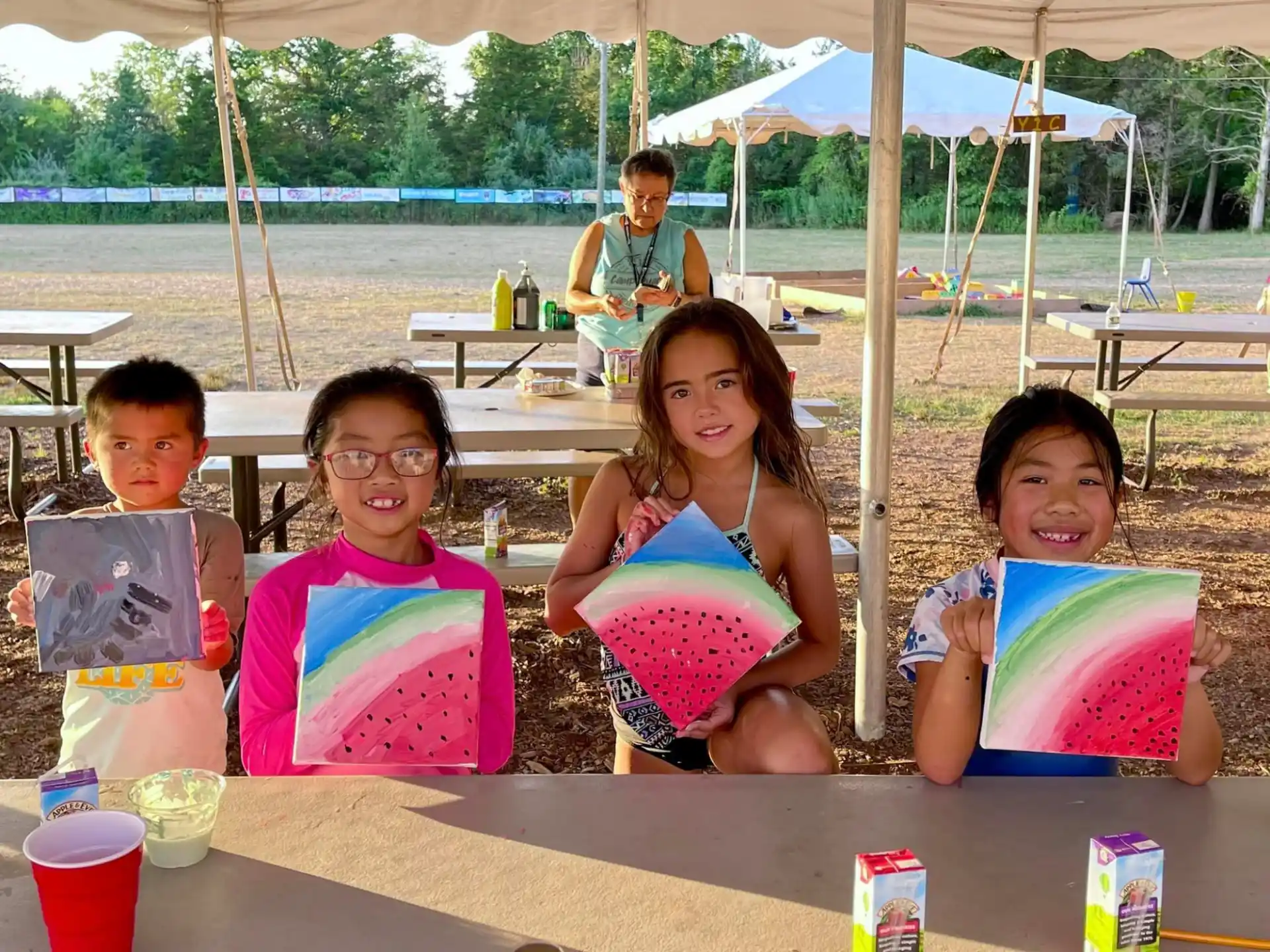 a group of girls sitting at a table with food and drinks