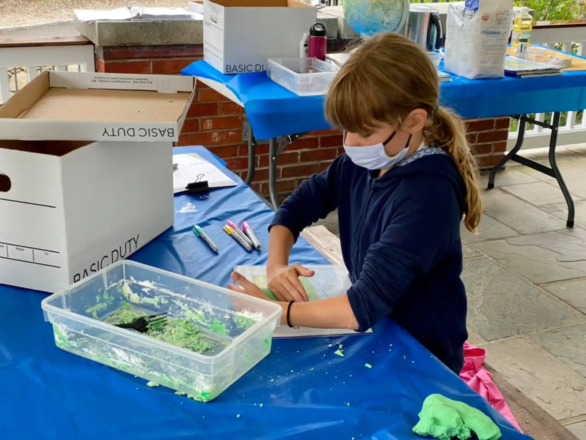 a young girl painting a green plant