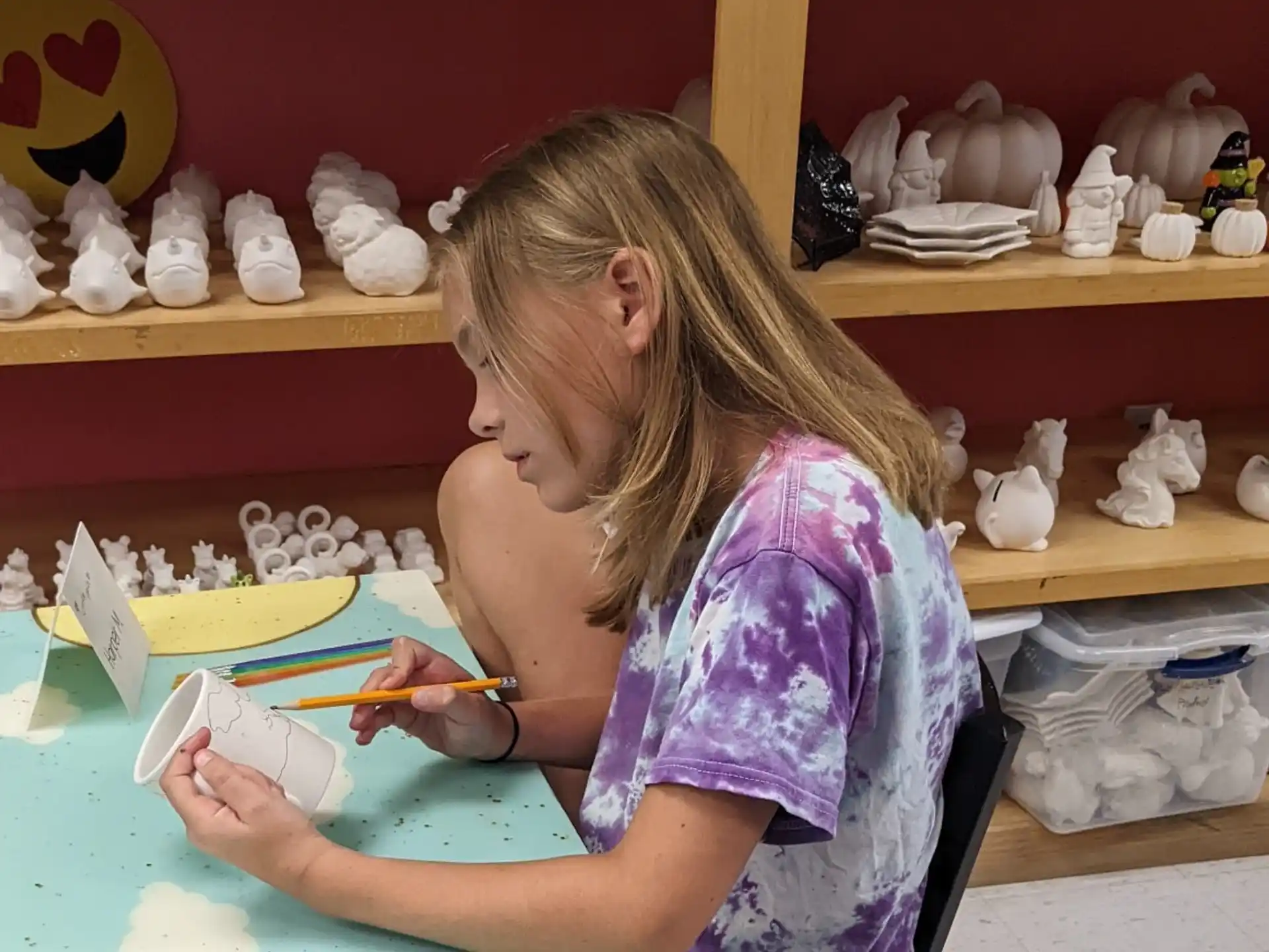 a girl painting on a blue table