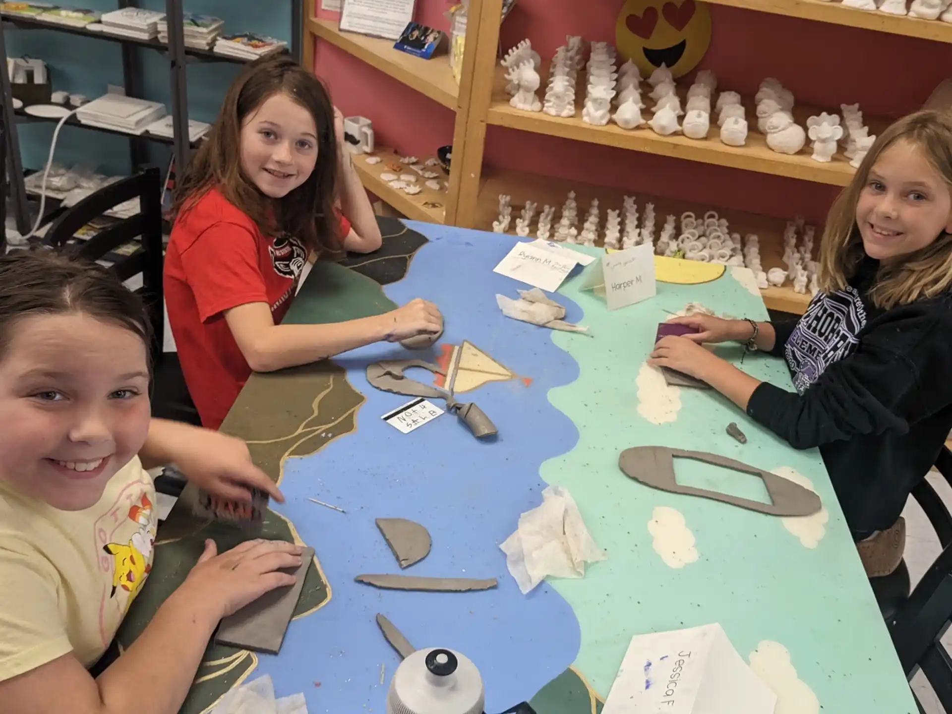a group of children sitting at a table with toys on it