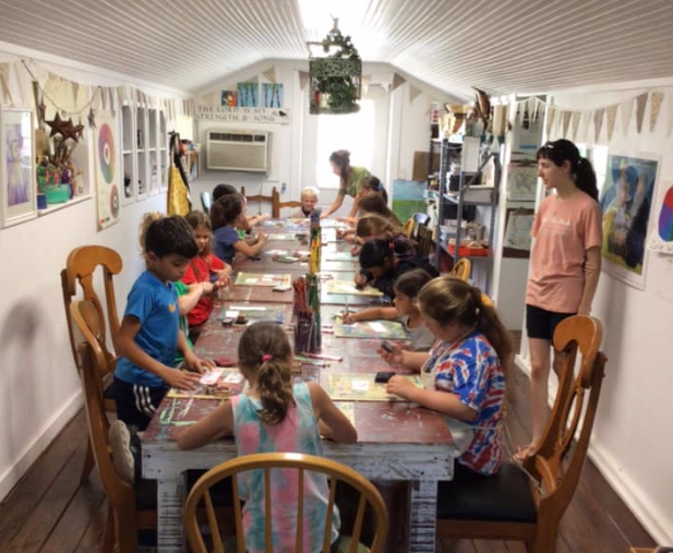a group of children sitting around a table