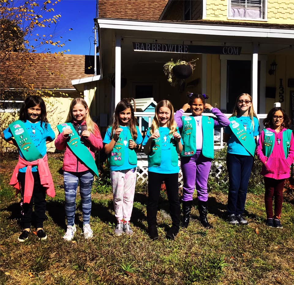 a group of girls posing for a photo in front of a house