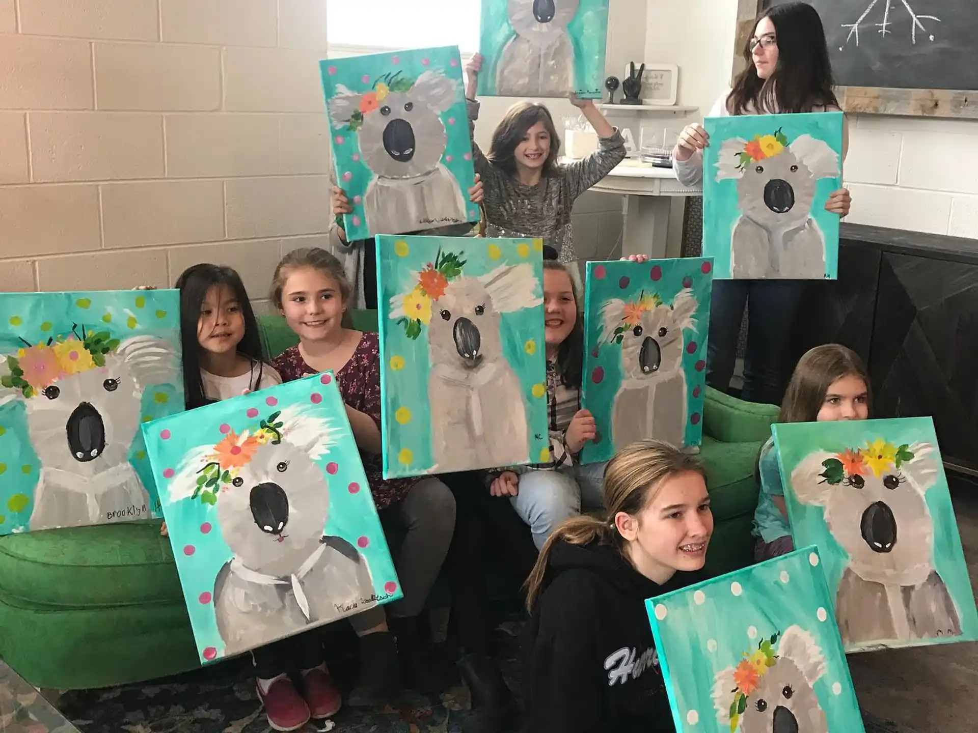 a group of children holding up artwork