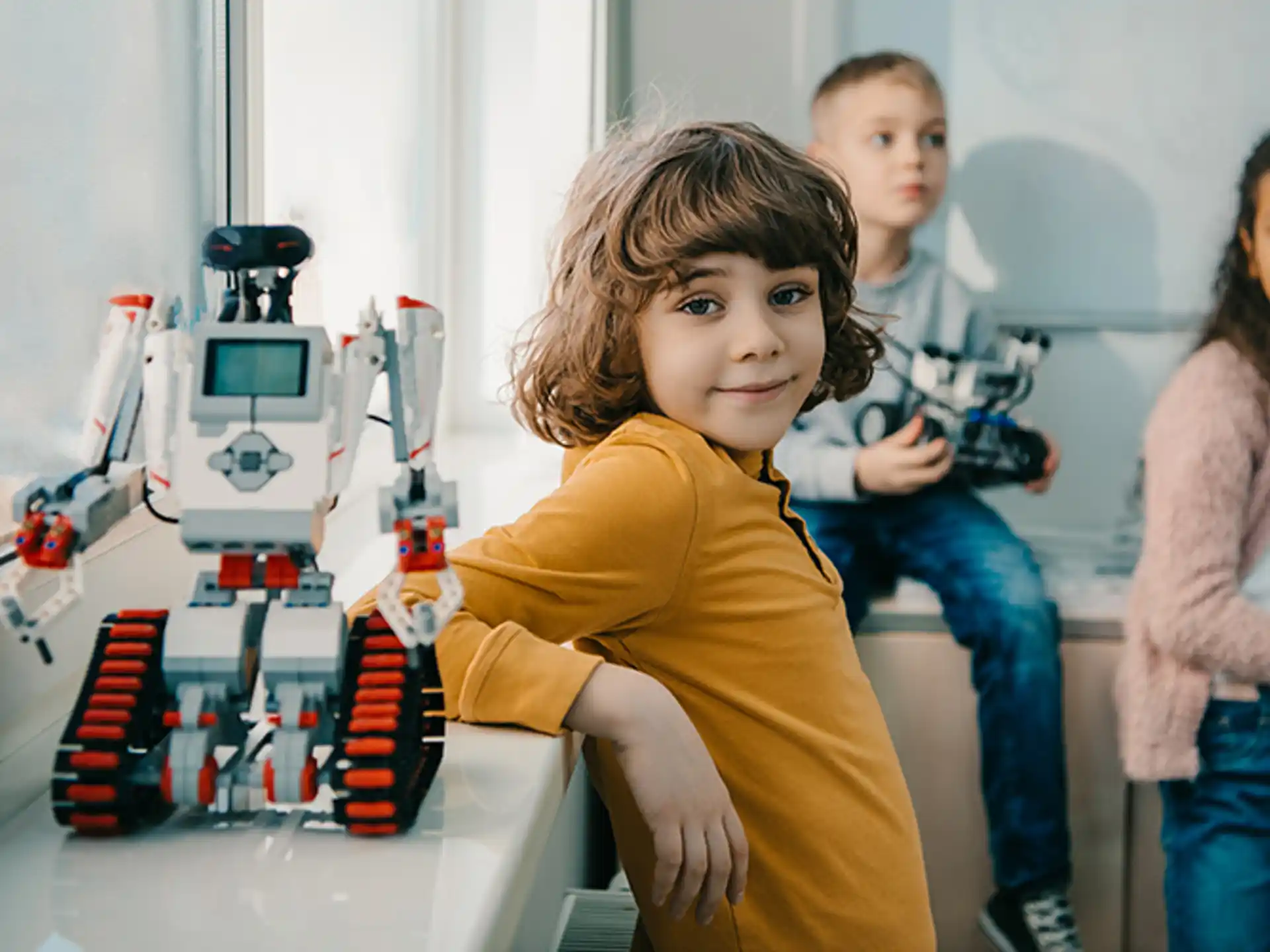 a young boy and girl standing next to a toy train
