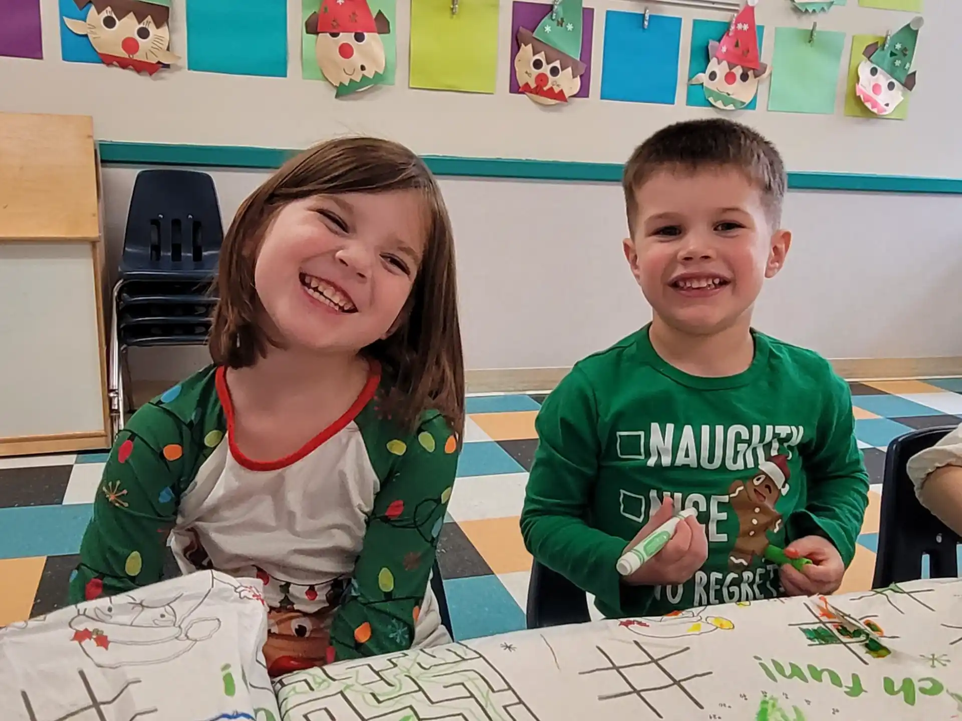 a boy and girl sitting at a table with a cake
