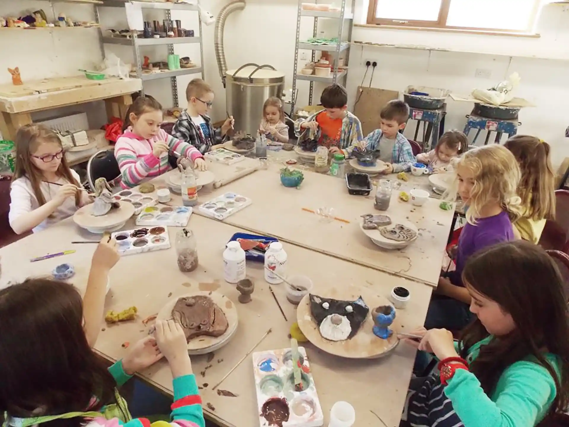 a group of children sitting around a table eating food