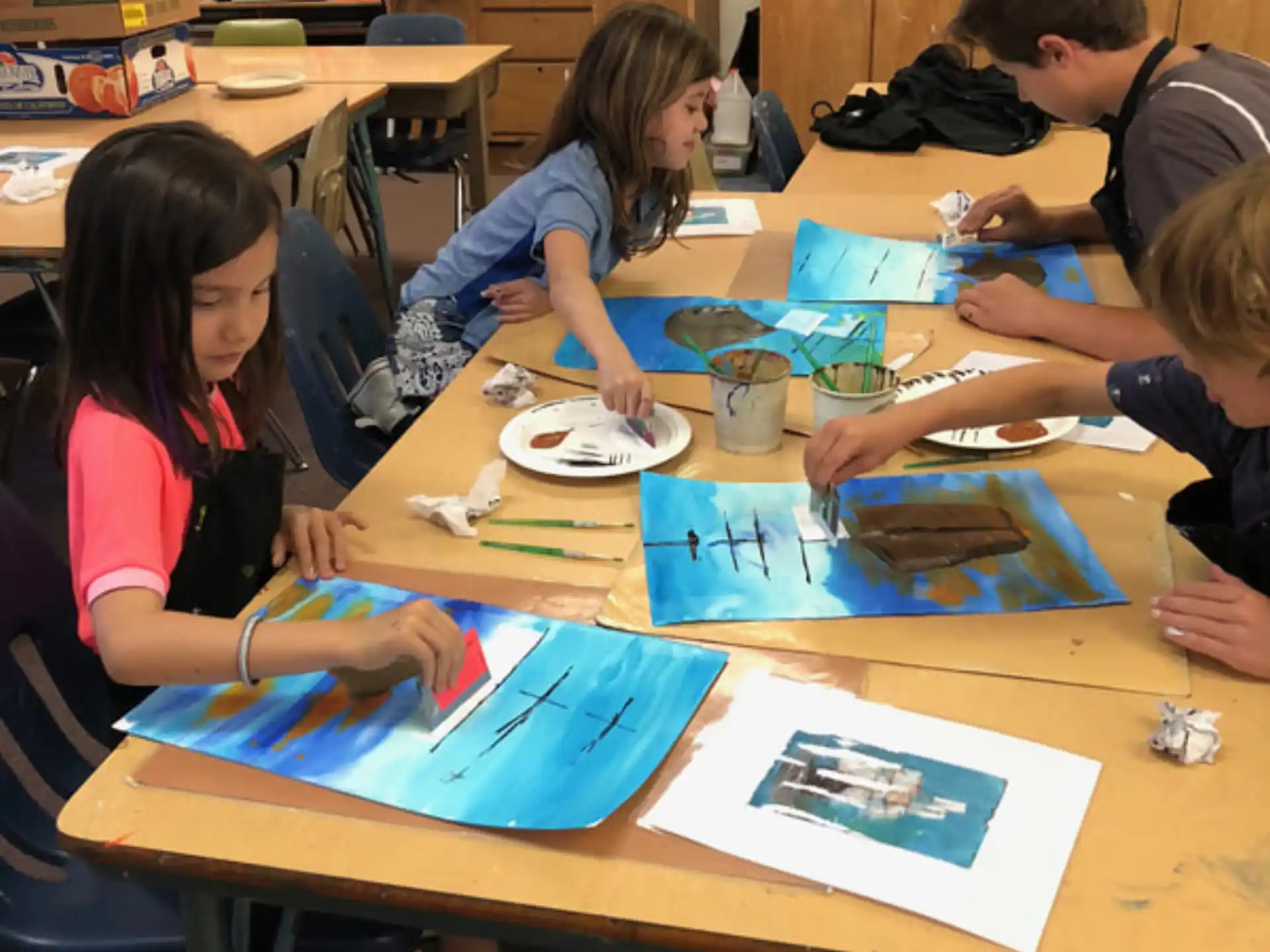 a group of children sitting at a table in a classroom