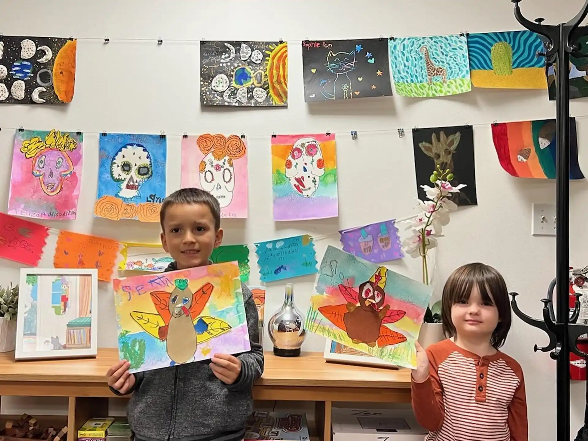 a couple of children holding up a piece of art