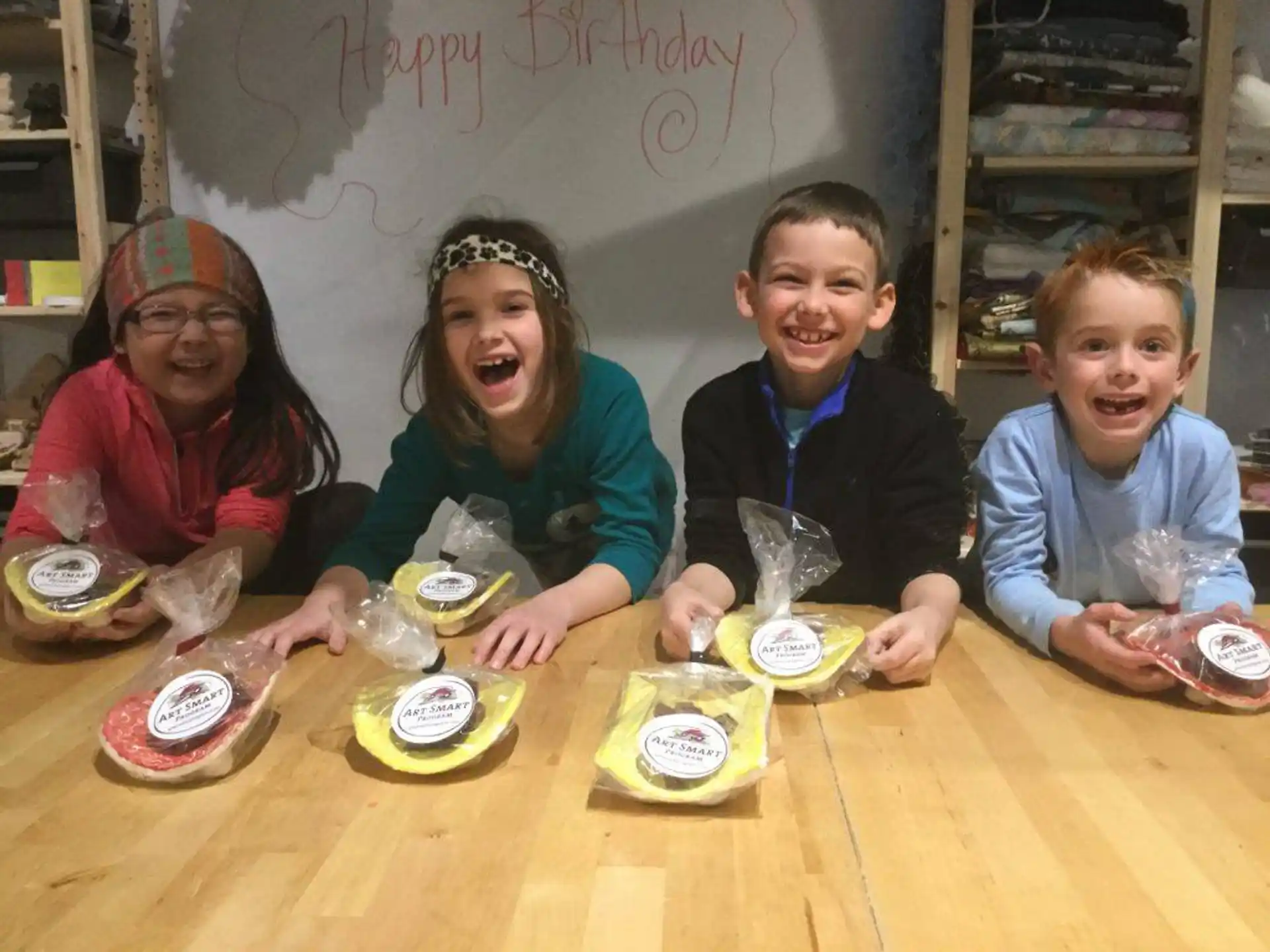 a group of kids sitting at a table with food