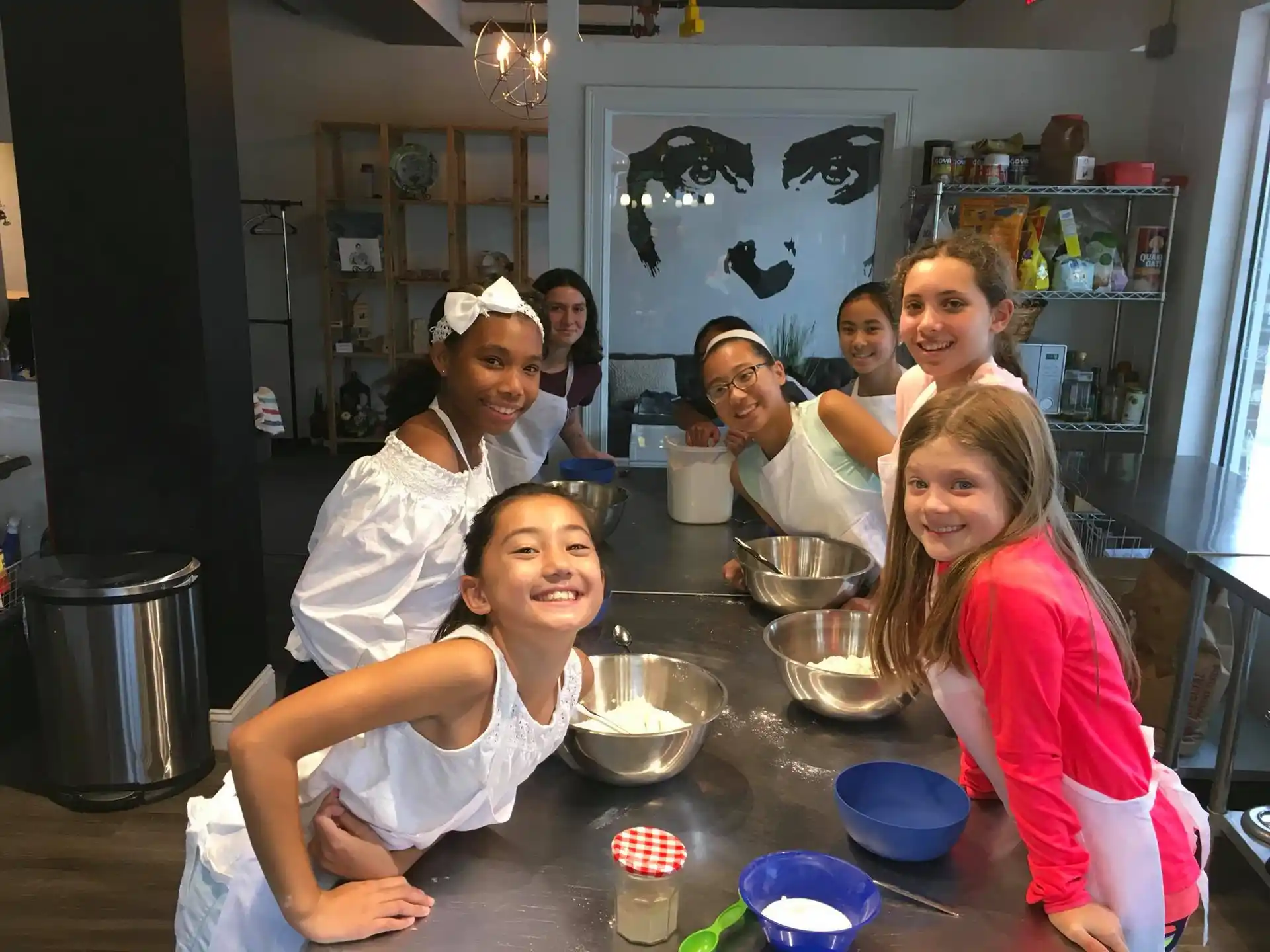 a group of people sitting at a table with food and drinks