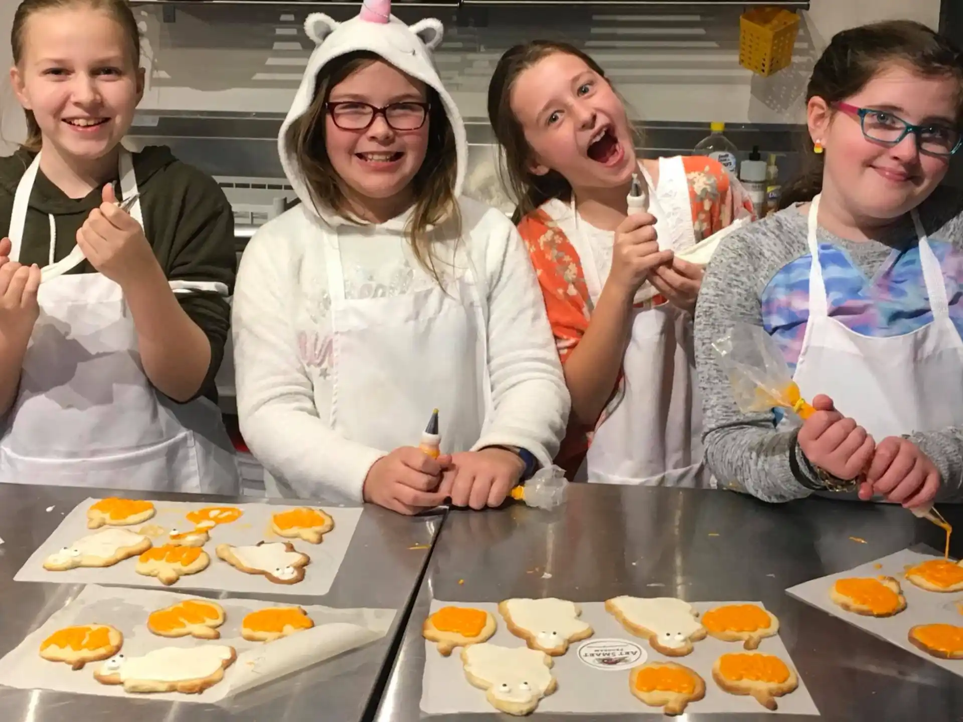 a group of people wearing white aprons and holding chopsticks