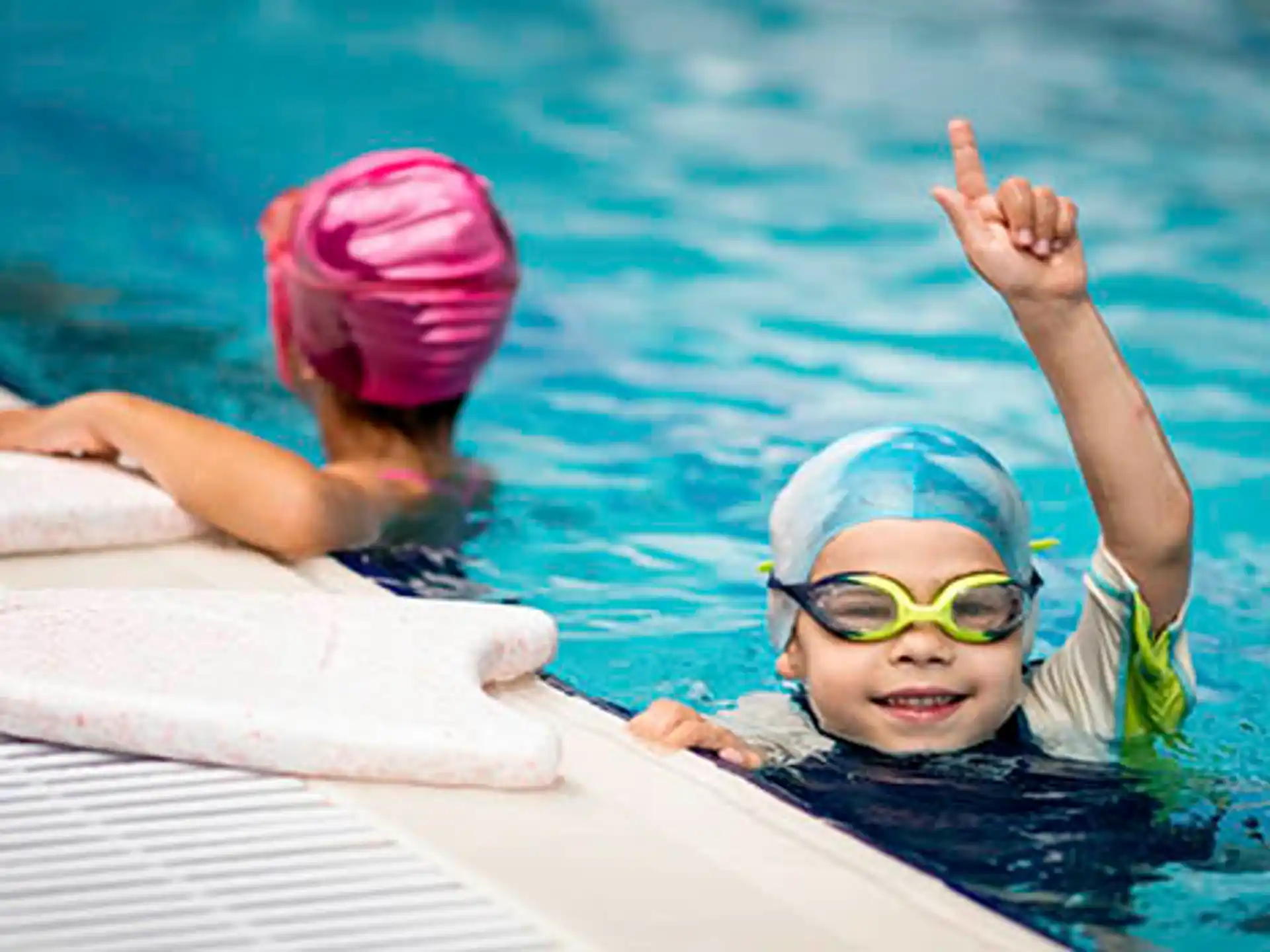 a couple of kids swimming in a pool