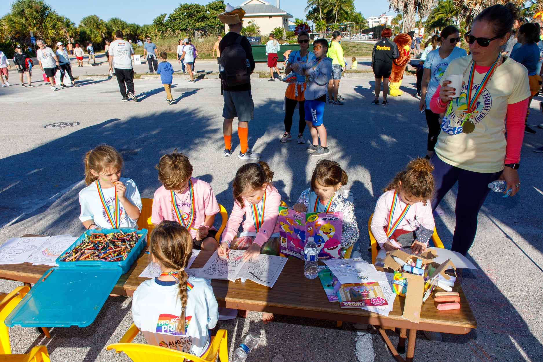 a group of children sitting at a table outside