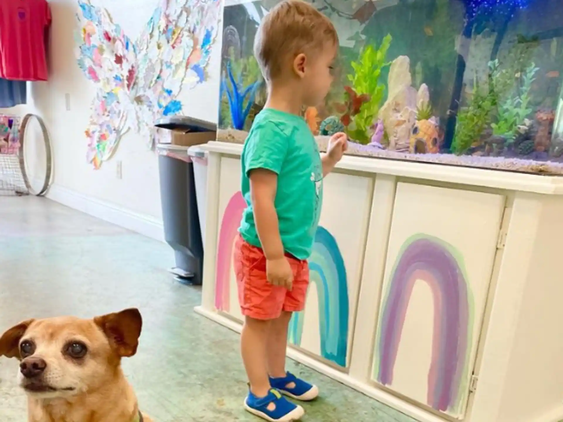 a child standing in front of a painting