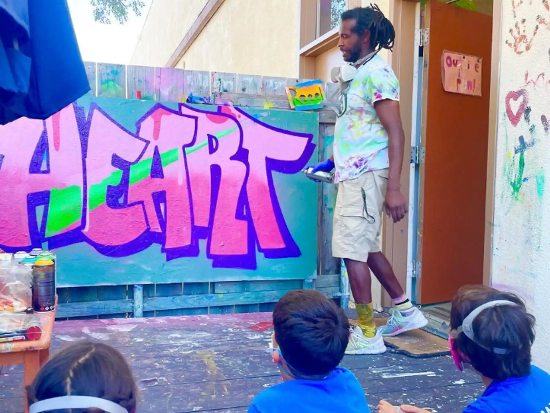 a person standing in front of a wall with graffiti