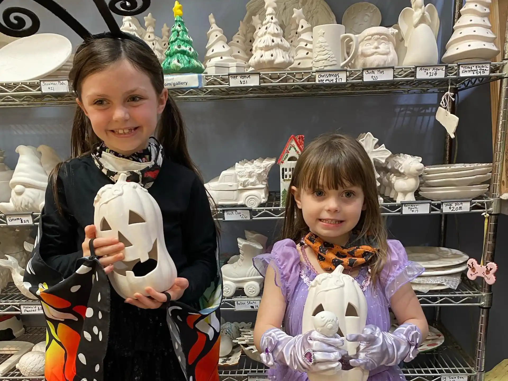 a couple of girls holding a stuffed animal posing for the camera