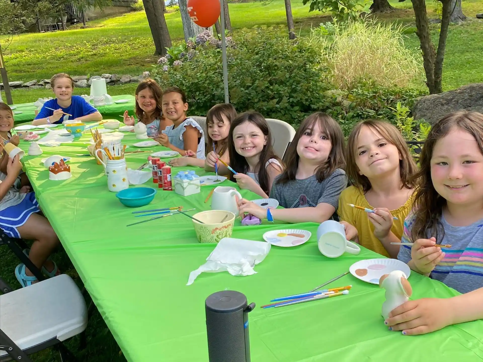 a group of children sitting at a table outside