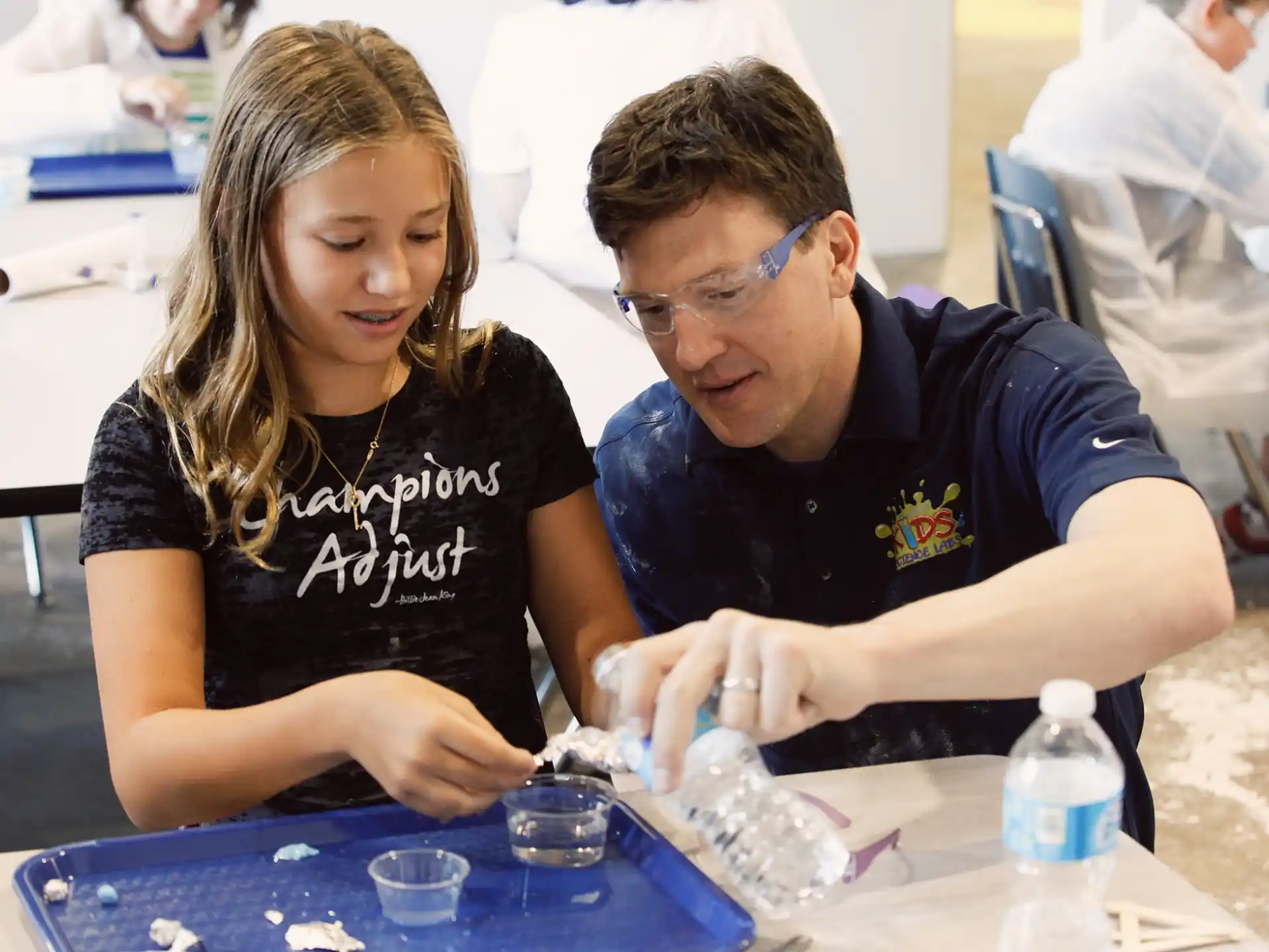 a man and a woman looking at a small model of a human